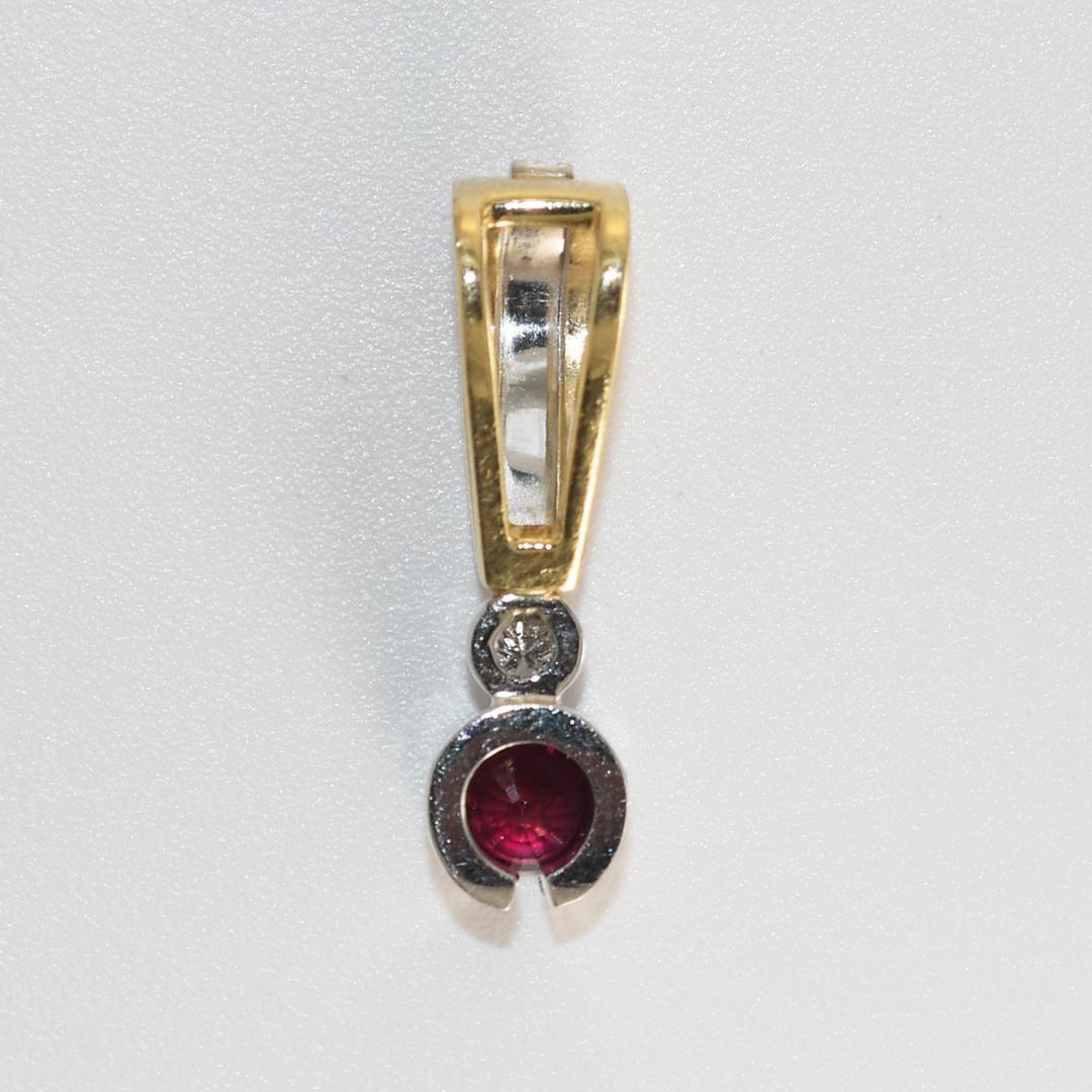 Pendente con rubino e diamante e montatura in oro bianco e giallo 14k.
Test del 56.5% di oro con un analizzatore di metalli XRF.
Il peso lordo del ciondolo è di 3,4 grammi.
Il rubino, taglio rotondo e brillante, è di colore rosso intenso e misura