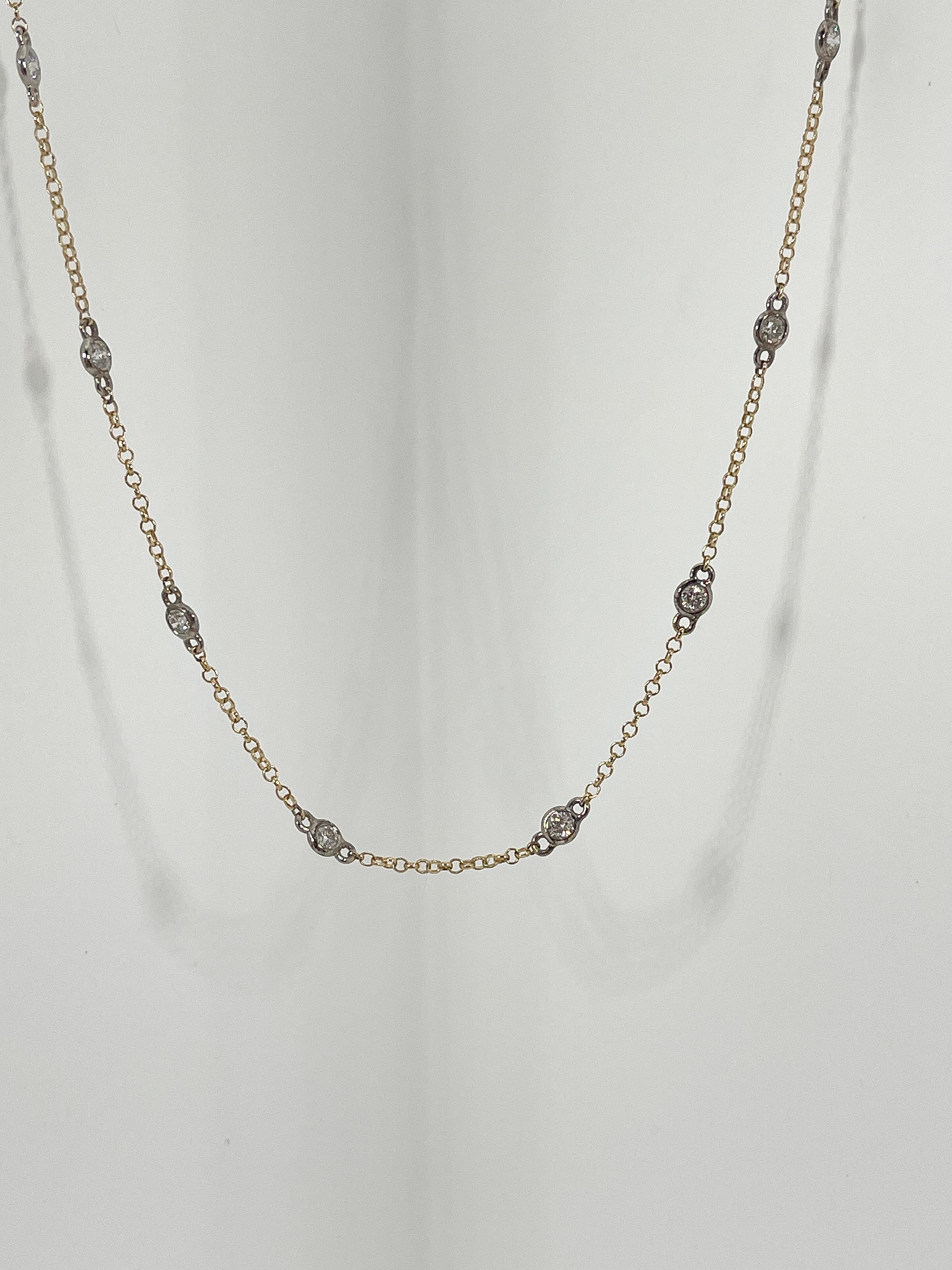 14k two toned diamonds by the yard necklace .75 CTW. The chain is yellow gold and all 18 round diamonds are set in a white gold bezel. The length of the necklace measures 21 inches, and the weight of the necklace is 3.17 grams.