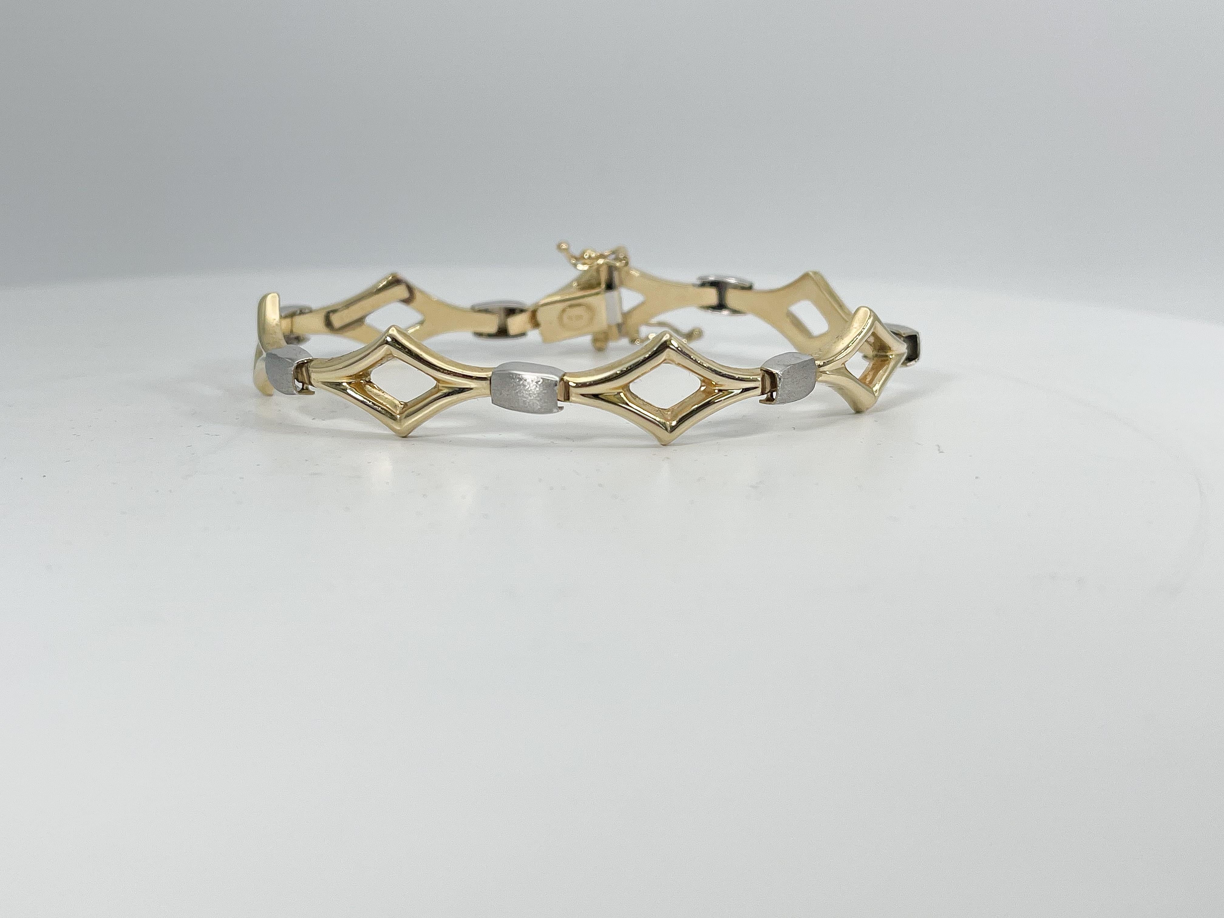 14k two toned fancy triangle bracelet. This bracelet comes with a figure 8 clasp to open and close, the width is 11.3 mm, the length is 7.5 inches, and it has a total weight of 12.78 grams.