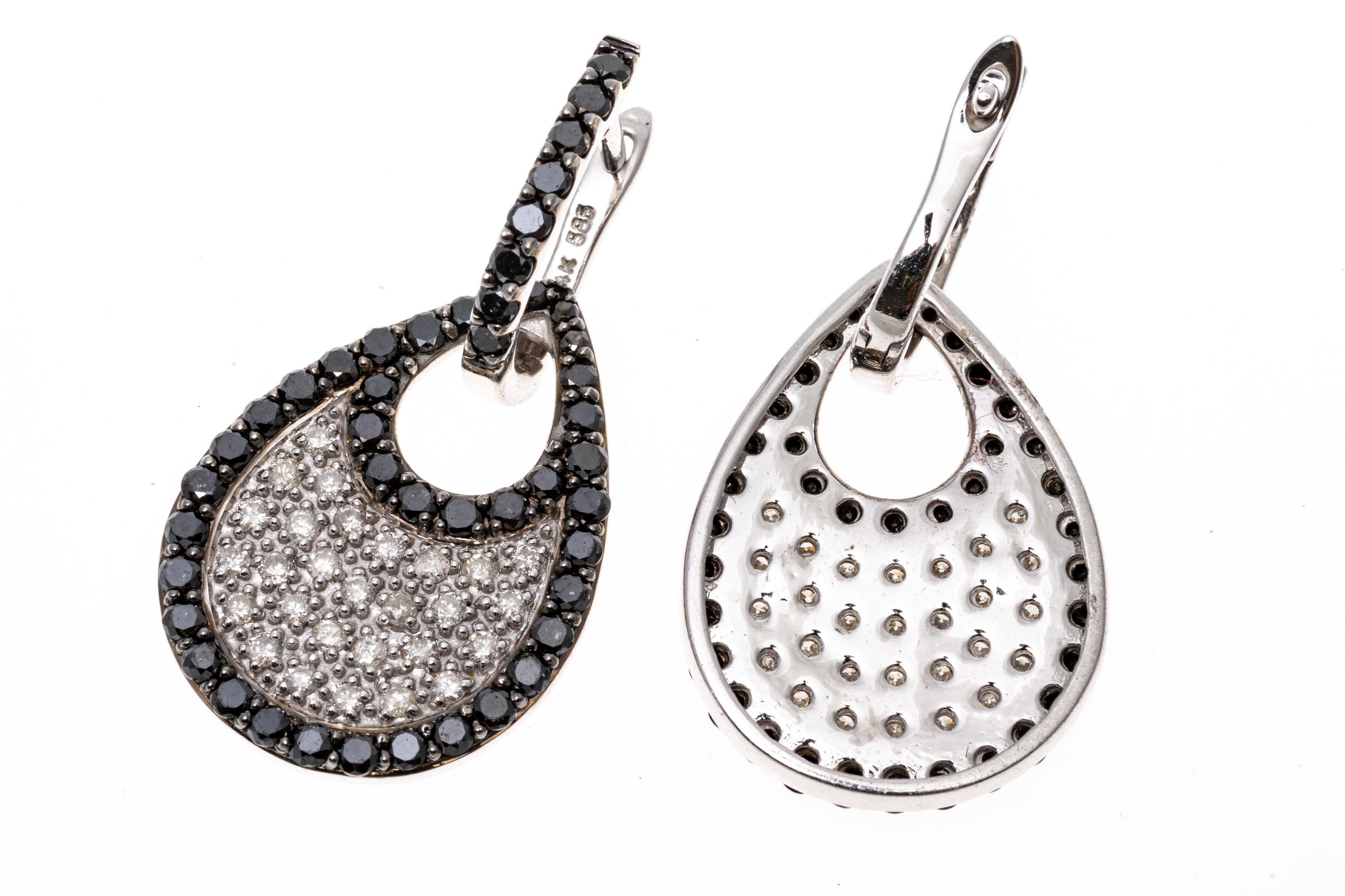 14k white gold earrings. These beautiful, versatile earrings contain a small hoop top, set with a row of round faceted, black diamonds. Suspended from the hoop is a pear shaped pendant, pave set in the center with round faceted, white diamonds,