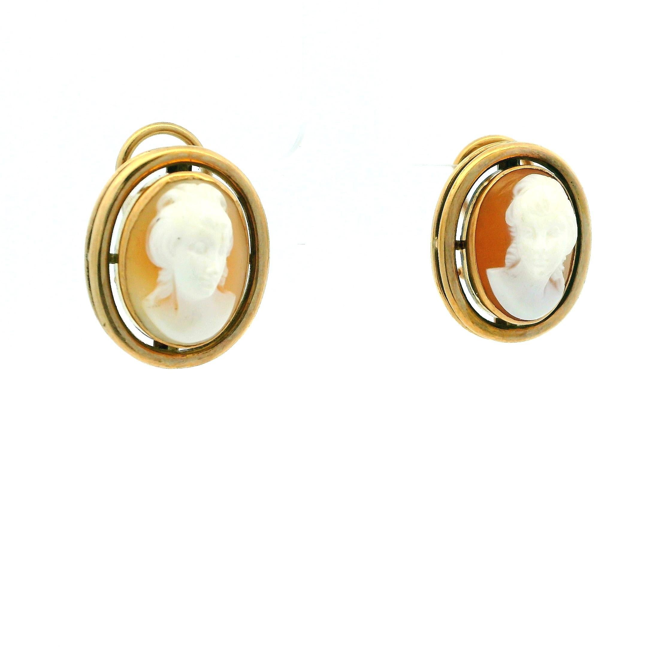 Espressione senza tempo dell'arte italiana, questi eleganti orecchini a cammeo presentano ritratti di conchiglie di corallo bianco finemente intagliati a mano e incorniciati in oro giallo 14 carati massiccio. Ogni cammeo raffigura un profilo