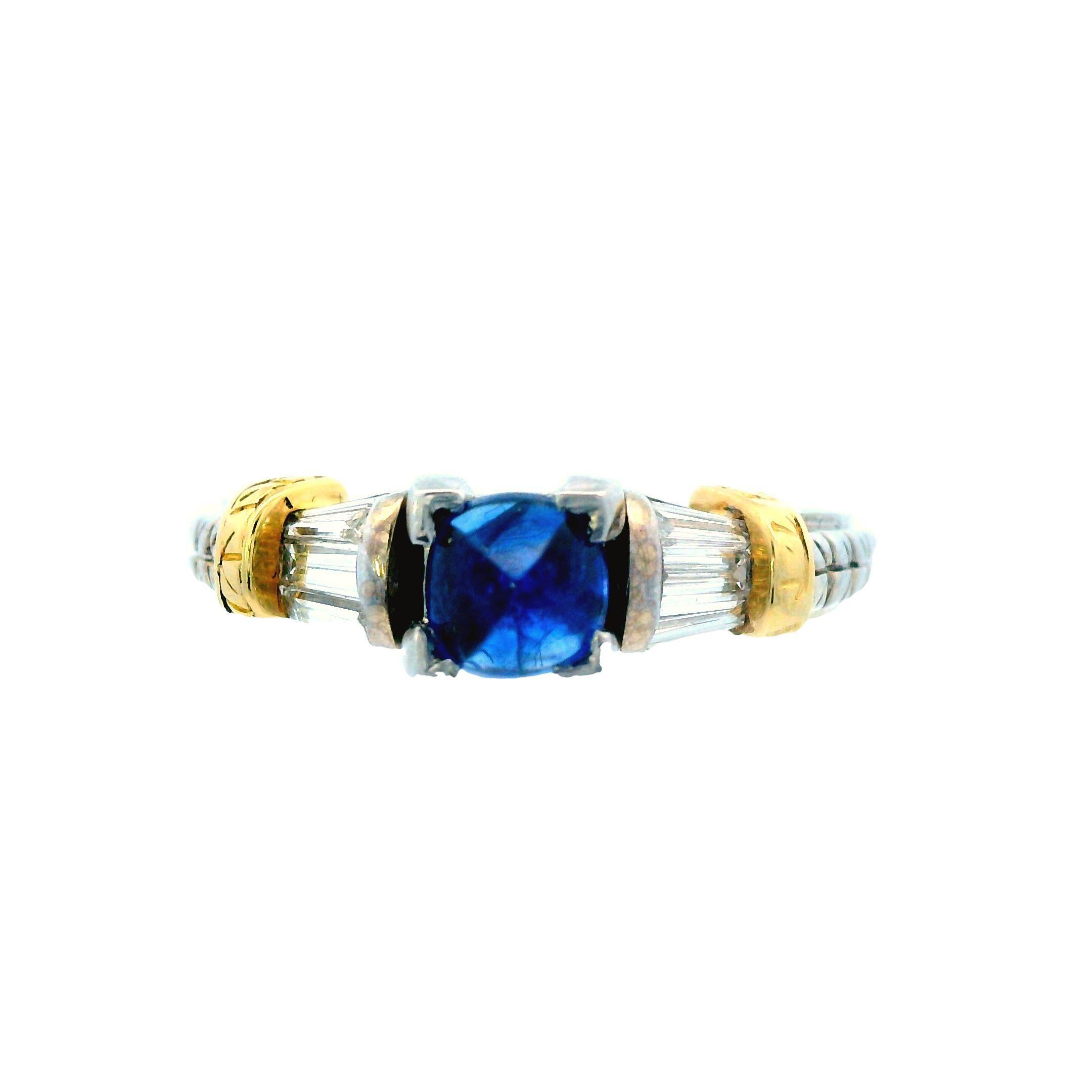 Cette bague exceptionnelle mêle harmonieusement l'or blanc et l'or jaune 14k pour mettre en valeur de superbes diamants baguettes blancs et un saphir bleu naturel à couper le souffle. La tige en or blanc de la bague présente des détails gravés