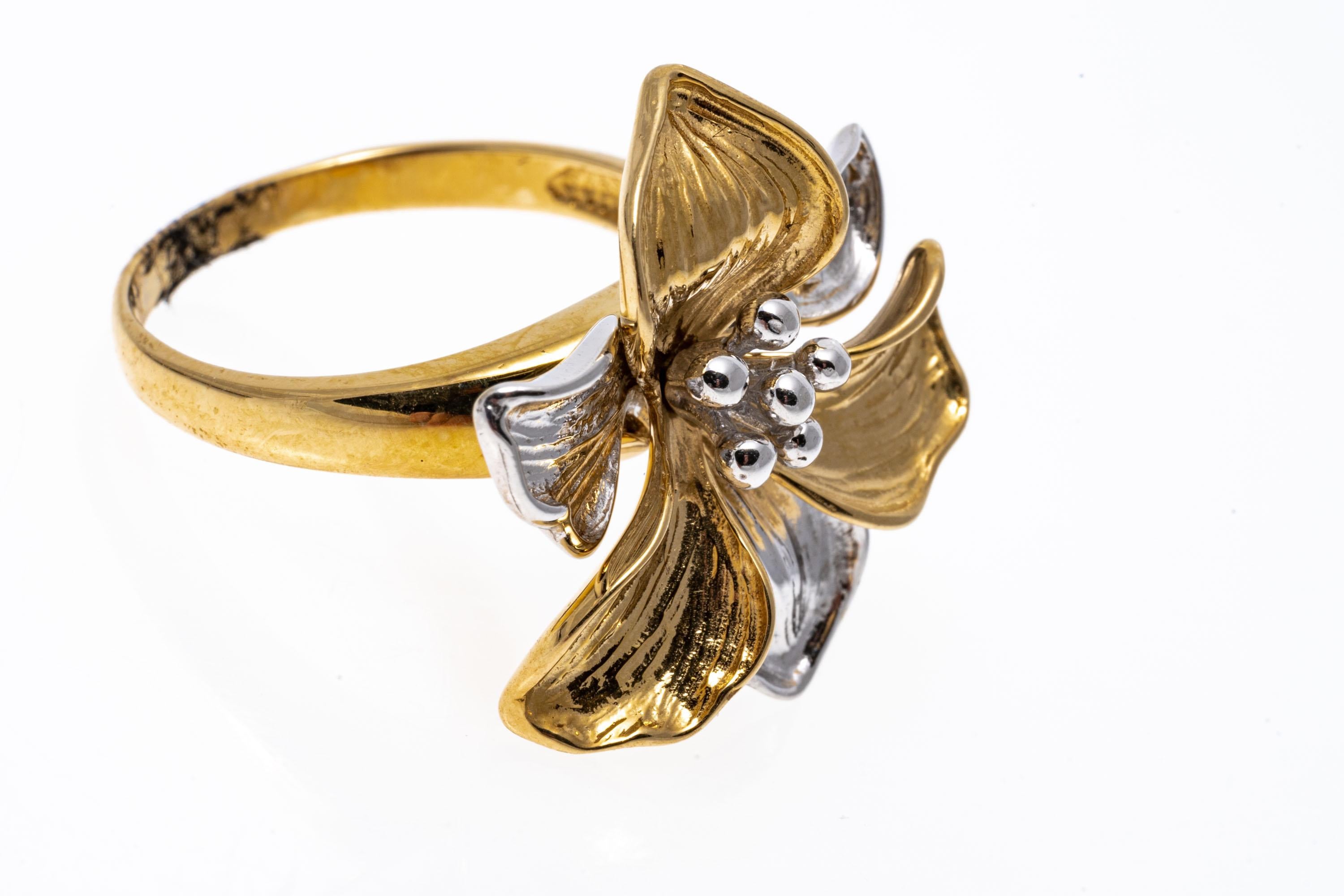 14k gold ring. This beautiful ring is a high polished finished, two tone figural flower motif ring, decorated with a beaded stamen center and finished with a high polished, yellow gold shank.
Marks: 14k
Dimensions: 13/16