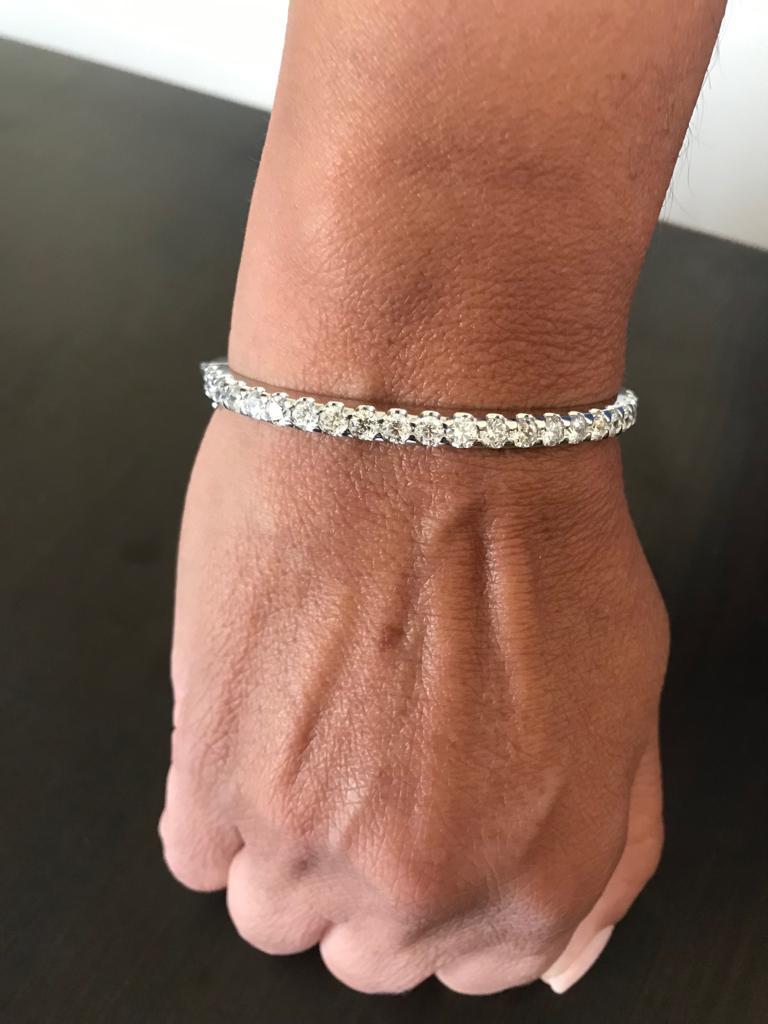 Half way diamond bangle set in 14K white gold. The bangle is set with 22 diamonds each weighing approximately 0.20 carats each. The total weight of the bangle is 4.43 carats. The color of the stones are G-H, the clarity is SI1-SI2. This bangle is