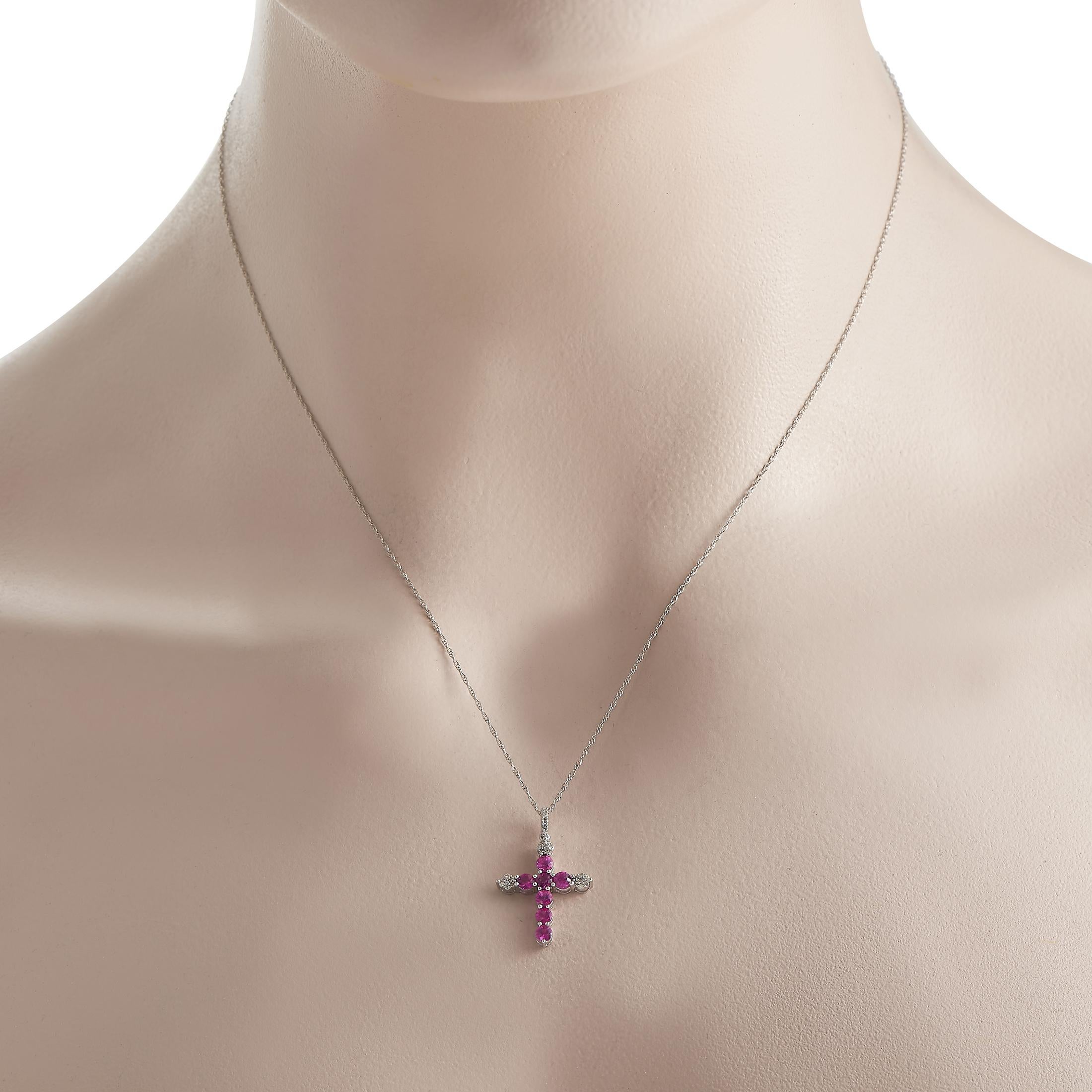 Consider this cross necklace as a beautiful reminder to enrich your spiritual journey. This piece is elegantly crafted in 14K white gold. It bears a cross pendant traced by seven pink sapphires and and clusters of petite round diamonds. The 1 x 0.55