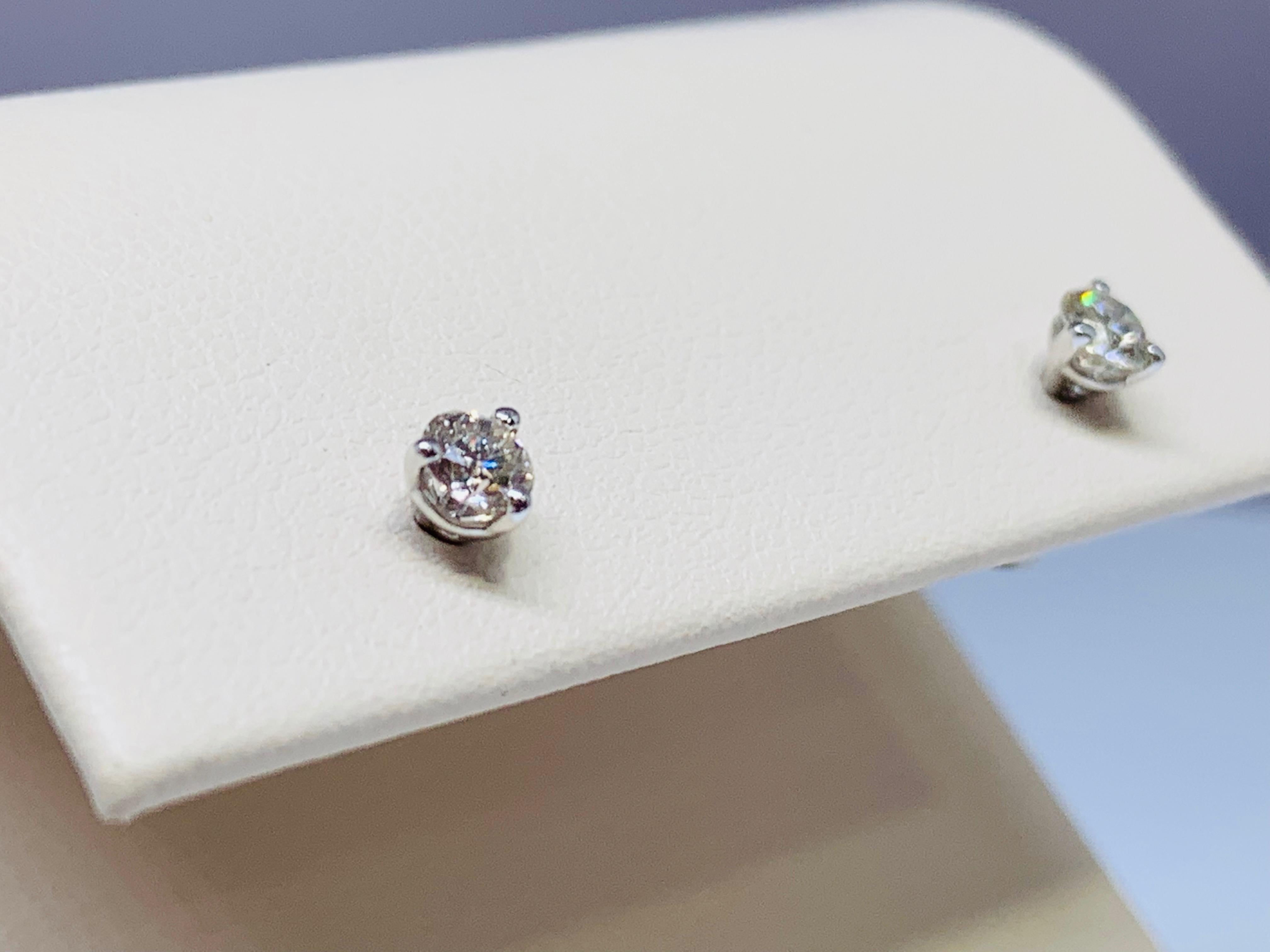 These 14K white gold diamond studs total 0.31 carats, holding a 0.155 carat diamond in each ear. The 3-prong martini style setting provides a classic look and includes sturdy 14K white gold tension backings. The diamond quality is estimated to be