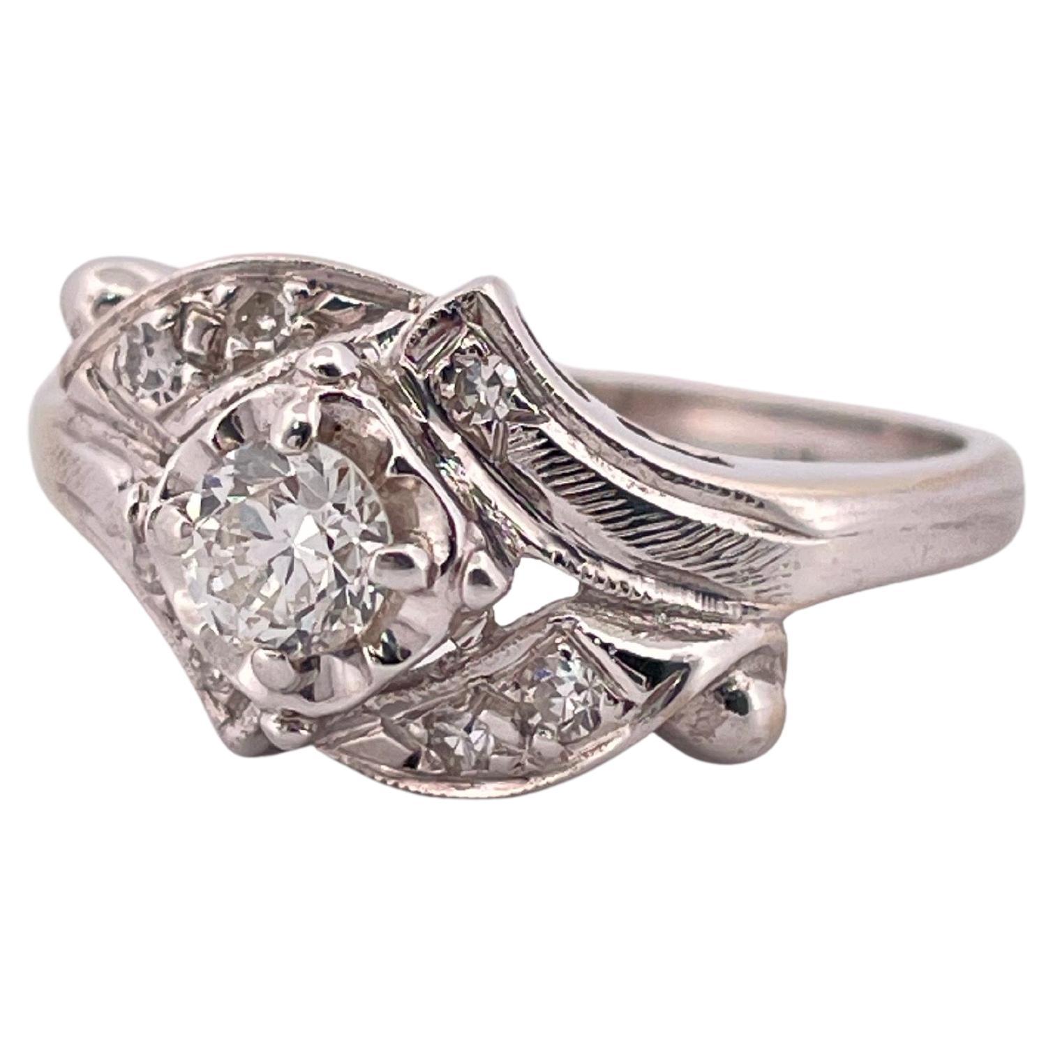 Fabriquée en or blanc lustré 14k, cette él�égante bague d'inspiration vintage présente un poids total de diamants d'environ 0,40 carat. En son centre, un diamant rond de taille brillant est solidement maintenu dans une monture classique à quatre