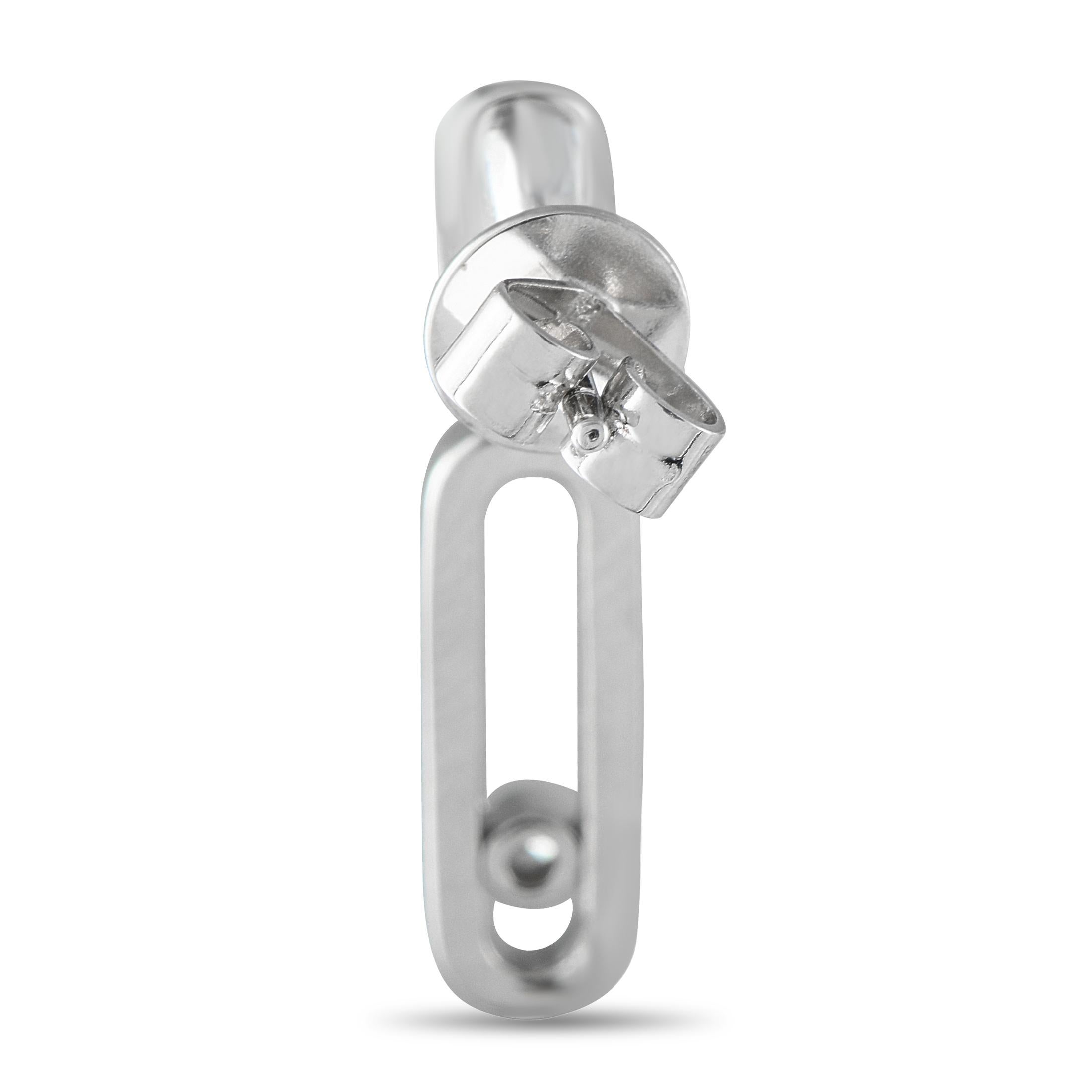 These subtly playful diamond earrings are designed to deliver a sparkle that moves with you. They're crafted in 14K white gold and feature an oval-shaped diamond cluster post with a push-back clasp. Dangling from each base is a diamond-traced link