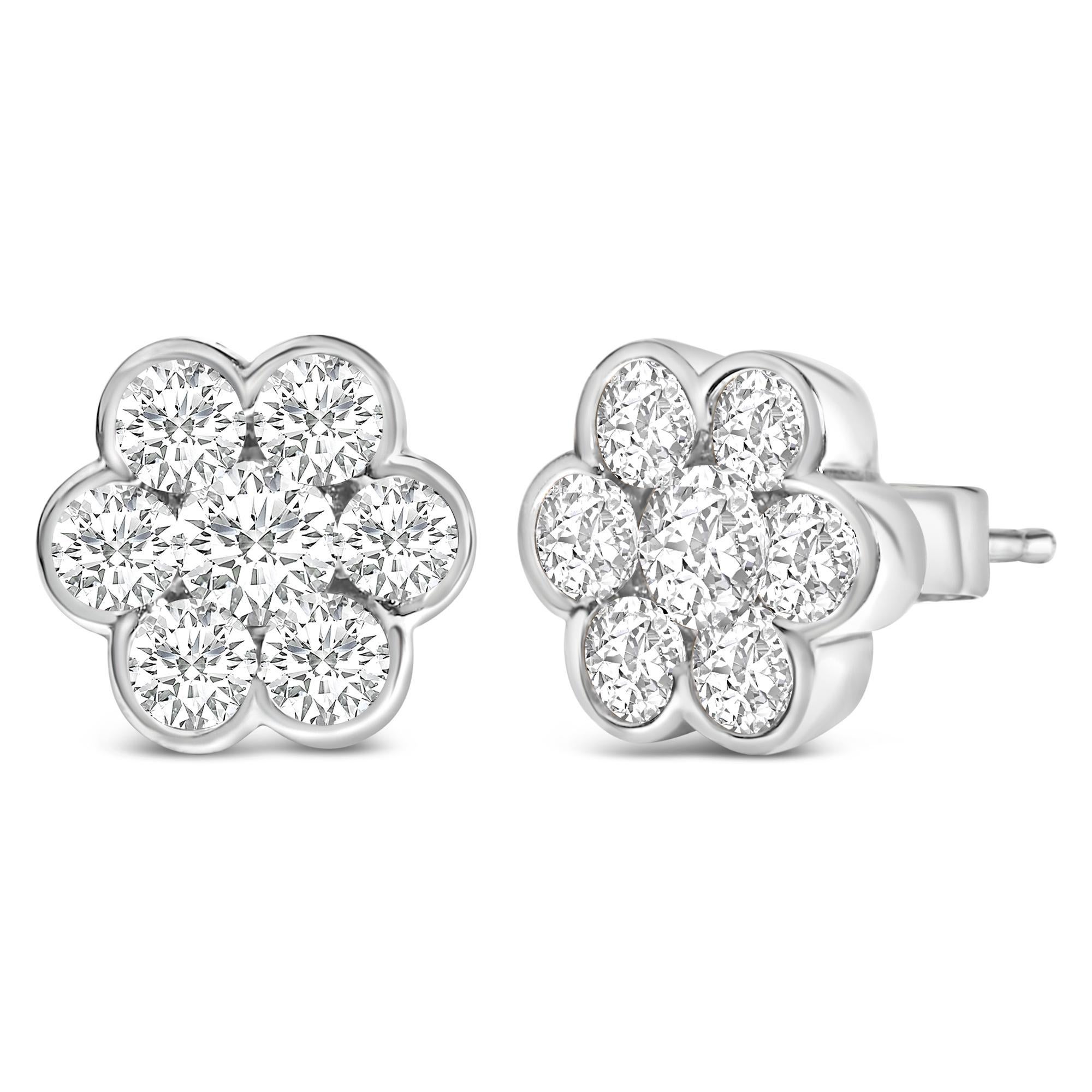 Plongez dans le summum de l'élégance avec ces exquises boucles d'oreilles en or blanc 14 carats, délicatement rhodiées pour accentuer leur allure radieuse. Conçu avec un motif floral envoûtant, chaque clou présente une grappe de sept diamants