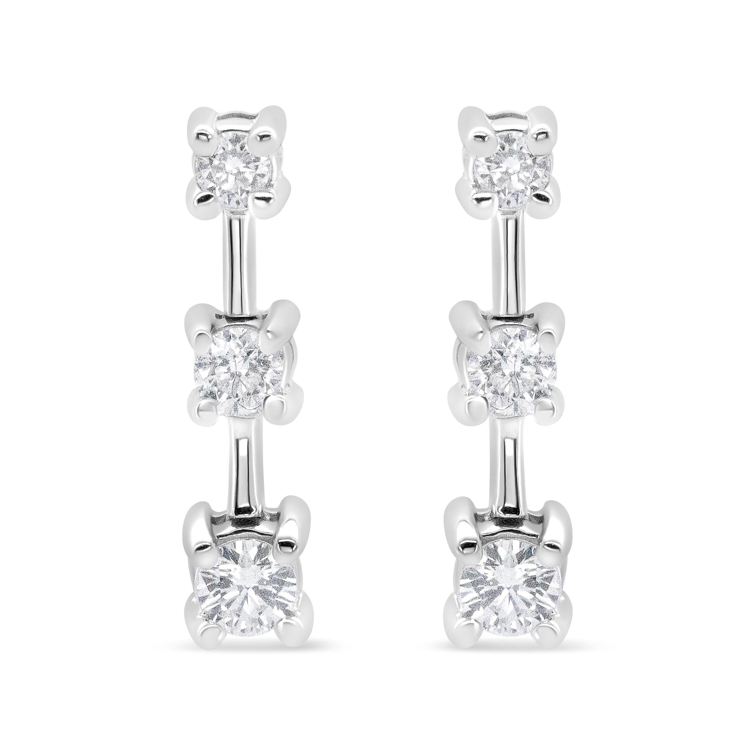 Diese fabelhaften Diamantohrringe mit drei Steinen sind in einem abgestuften Design gefasst, bei dem der kleinste Stein oben und der größte unten in aufsteigender Reihenfolge der Größe angeordnet ist. Der Tropfen mit den drei Steinen ist ein Symbol