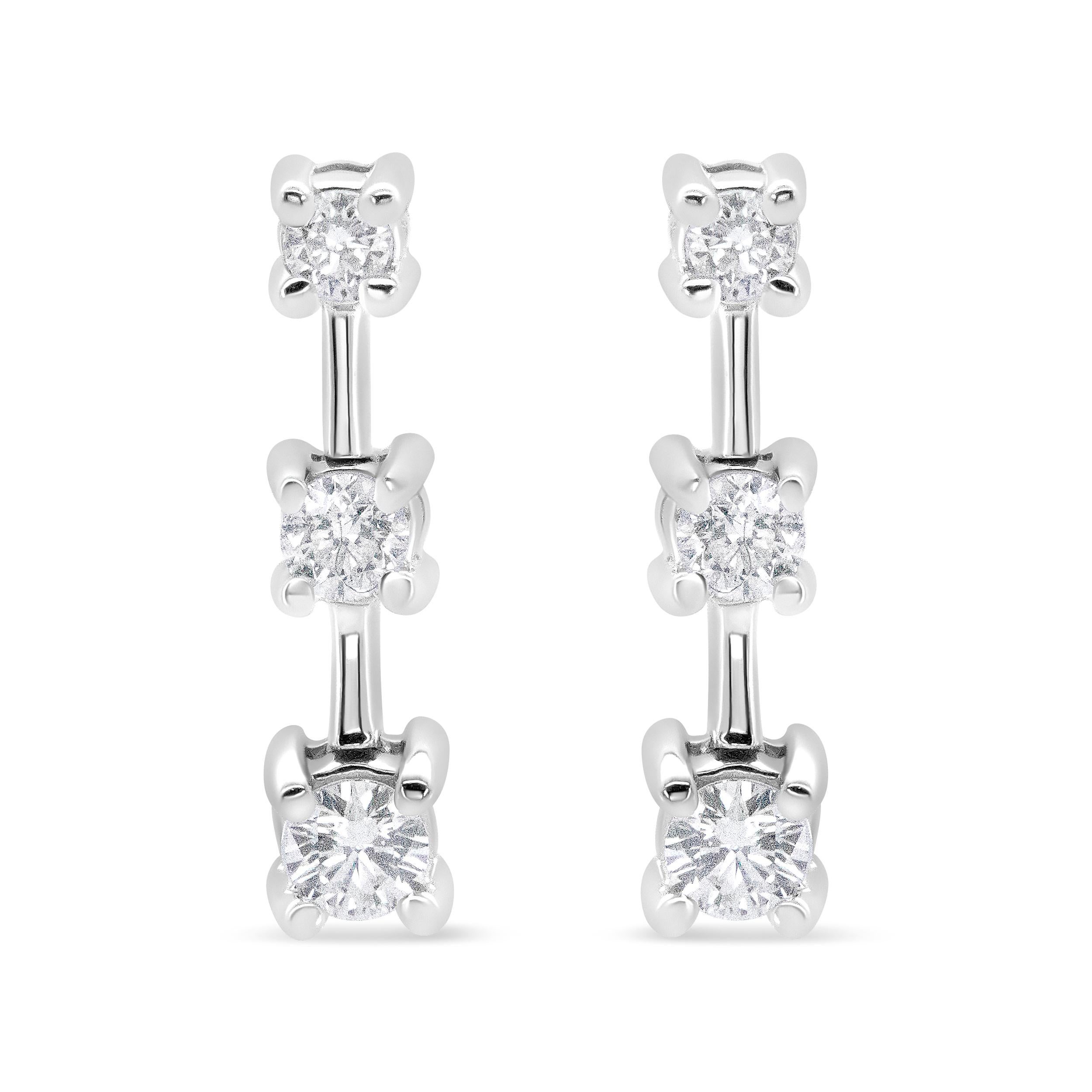 This fabulous three stone diamond earrings are set in a graduating design that align with the smallest stone at the top and the largest at the bottom in the ascending order of size. The three stone drop is a symbolism of one's past, present and