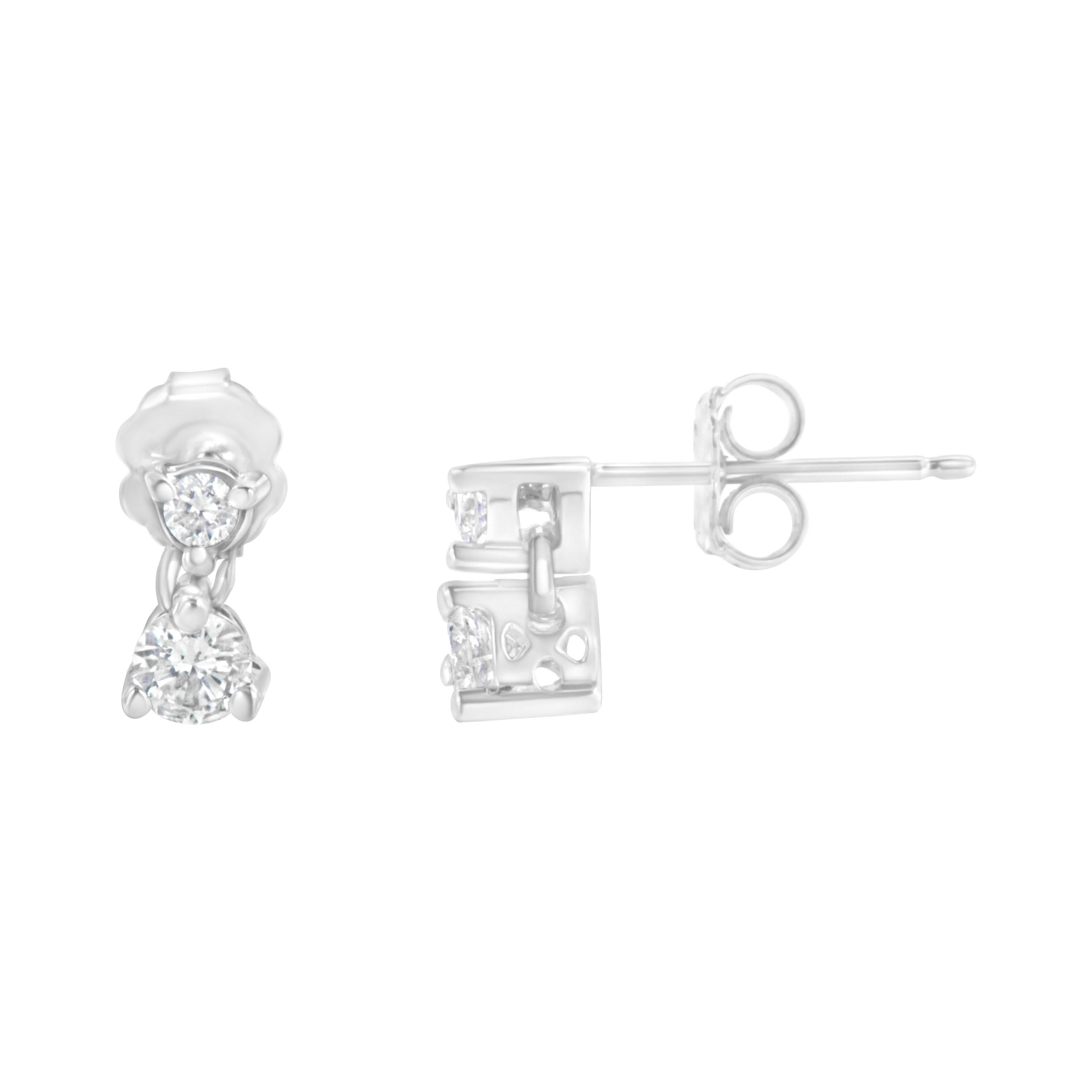 With a simple and elegant design, these 14k white gold dangle stud earrings will enhance any ensemble. 1/2 carat TDW of round cut diamonds glimmer in these adorable earrings that finish off with a secure push back secure fit. These natural diamonds
