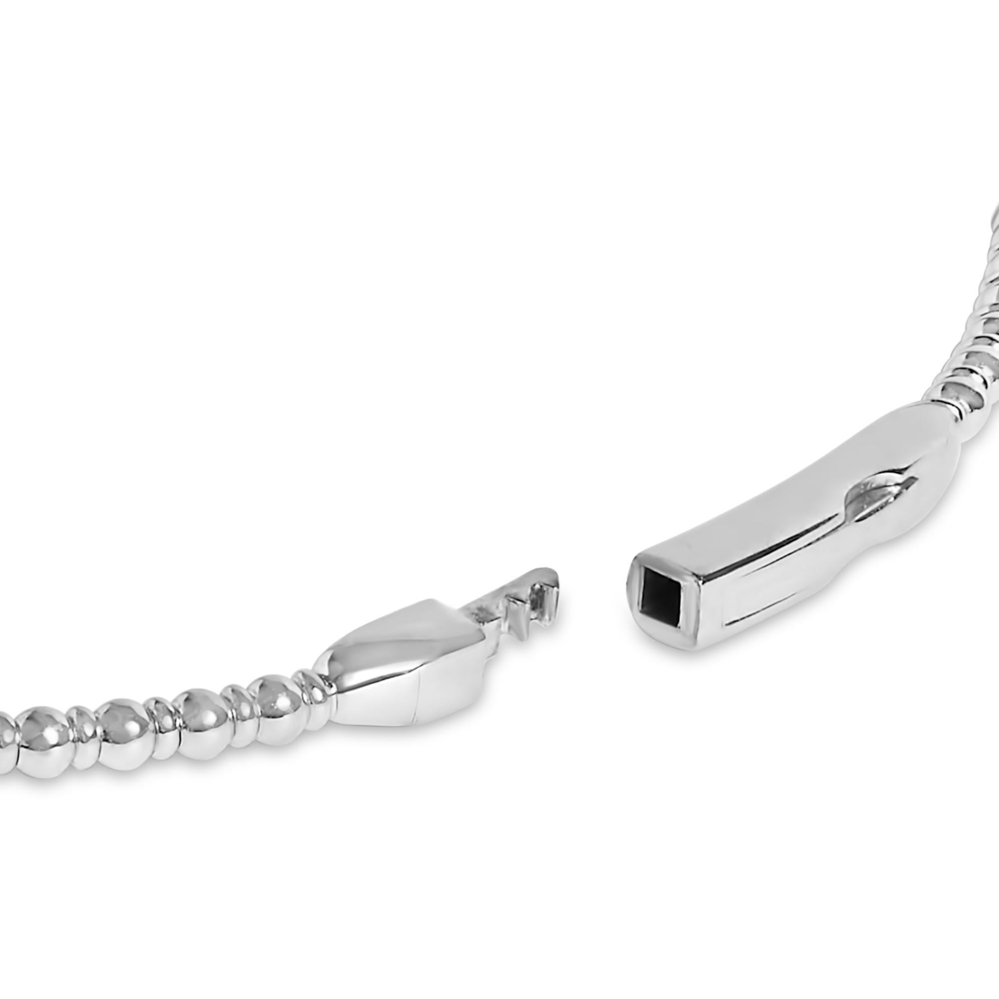 Embellished with a shimmering constellation of natural diamonds, this exquisite bangle, crafted from 14K white gold, gleams with a sophisticated rhodium polish. The intricate quatrefoil clover design, wherein each petal is meticulously adorned with