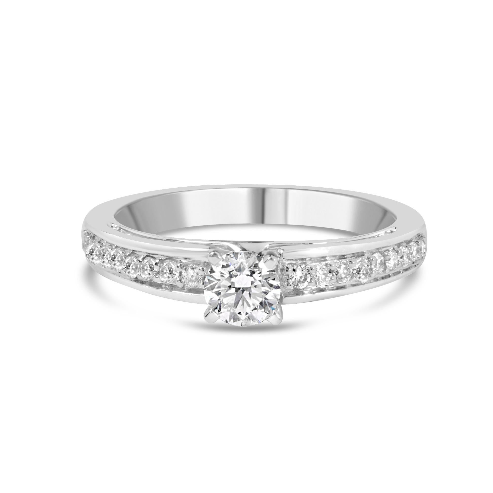 Embrace the celebration of love with this exquisite 14K white gold engagement ring, thoughtfully plated with rhodium for an enduring luster. At its heart lies a 1/3 carat round brilliant cut diamond, cradled by four robust prongs, radiating with a