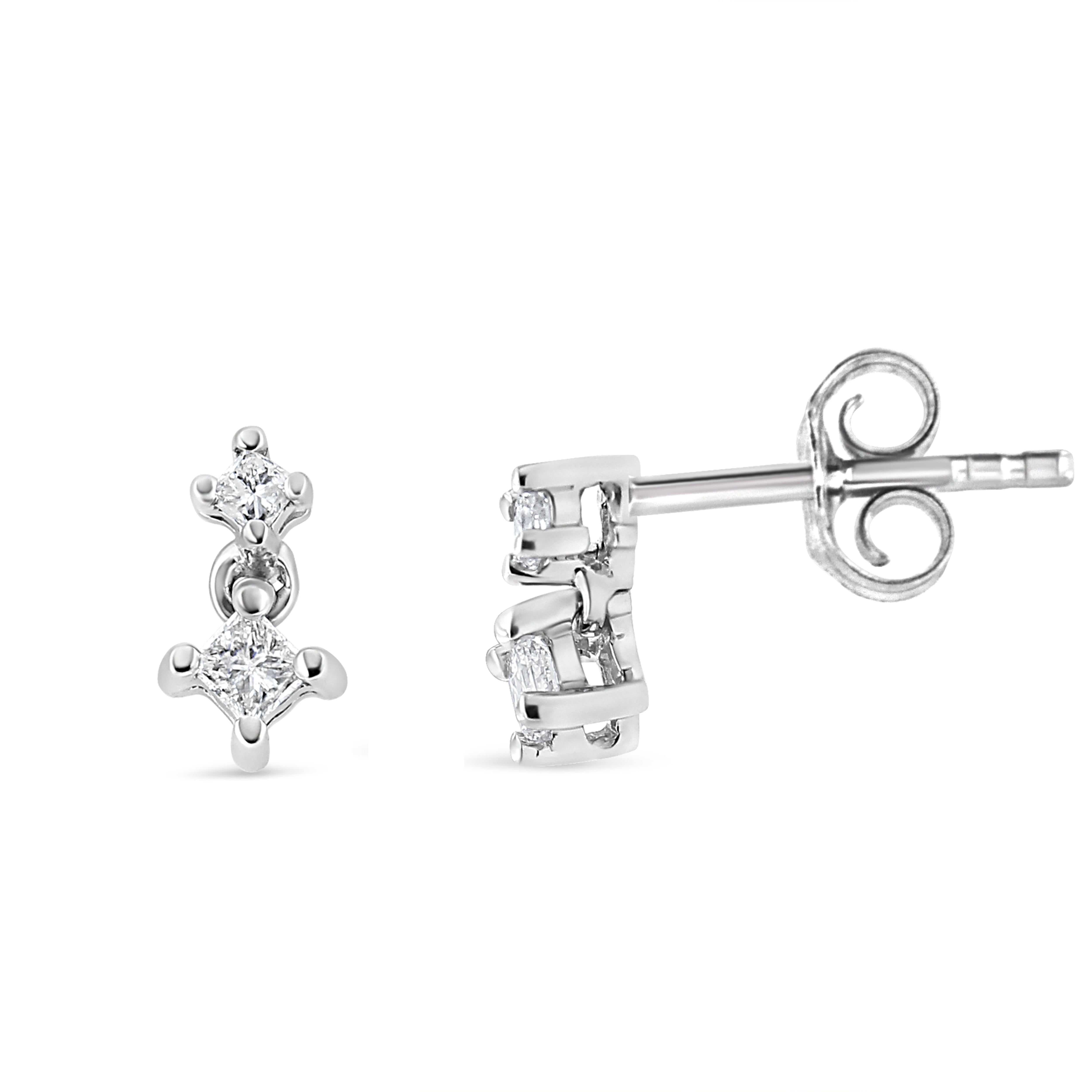 Revel in the timeless elegance of these stunning 14K white gold double diamond drop earrings, where style converges with splendor. Designed with meticulous attention to detail, each earring begins with a sparkle of a round diamond, followed