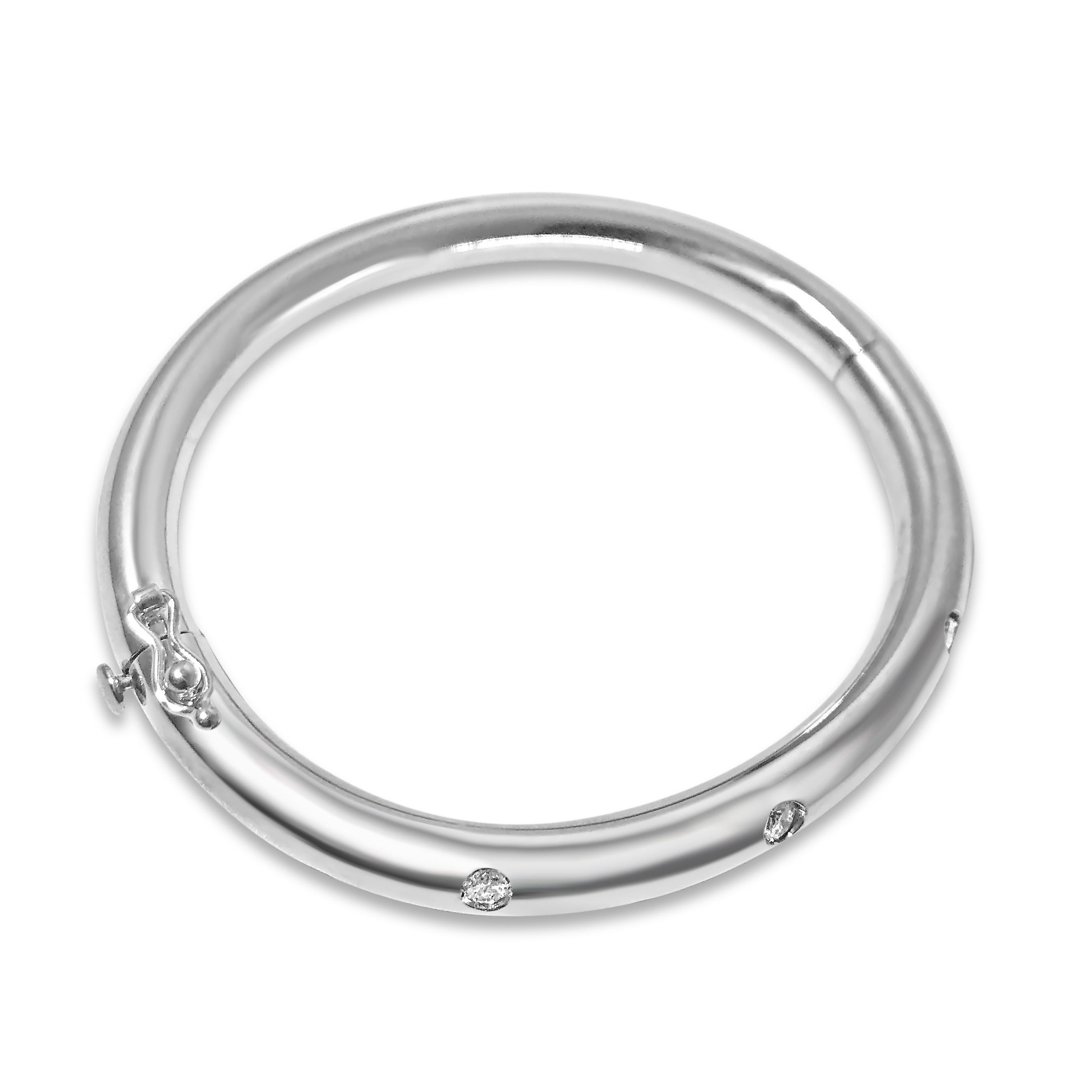 Our 14K white gold ¼ inch T-7 bangle is dotted with 7 round 2.9mm white diamonds, totaling 0.70ct. The oval bracelet features a snap & hinge closure.

Specifications:
- Stone(s): 2.9mm Diamonds
- Diamond-Cut & Clarity: 0.70ct. Round
- Dimention: 6