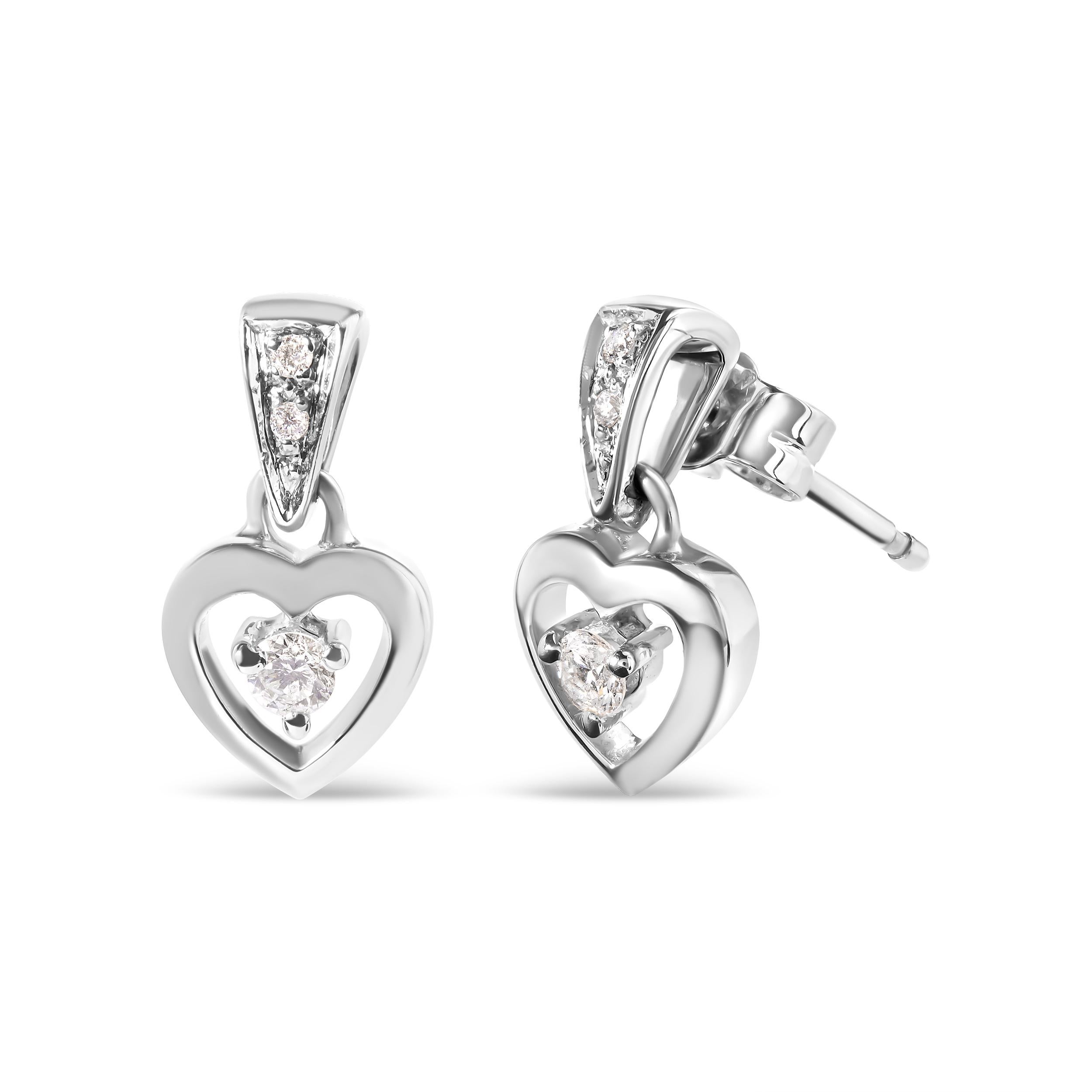 You will fall in love with these beautiful dangle heart stud earrings. Fashioned in 14k white gold, they feature 1/6 ct TDW of twinkling round cut diamonds. A cut out of a heart holds in its center a round cut diamond and delicately dangles from a