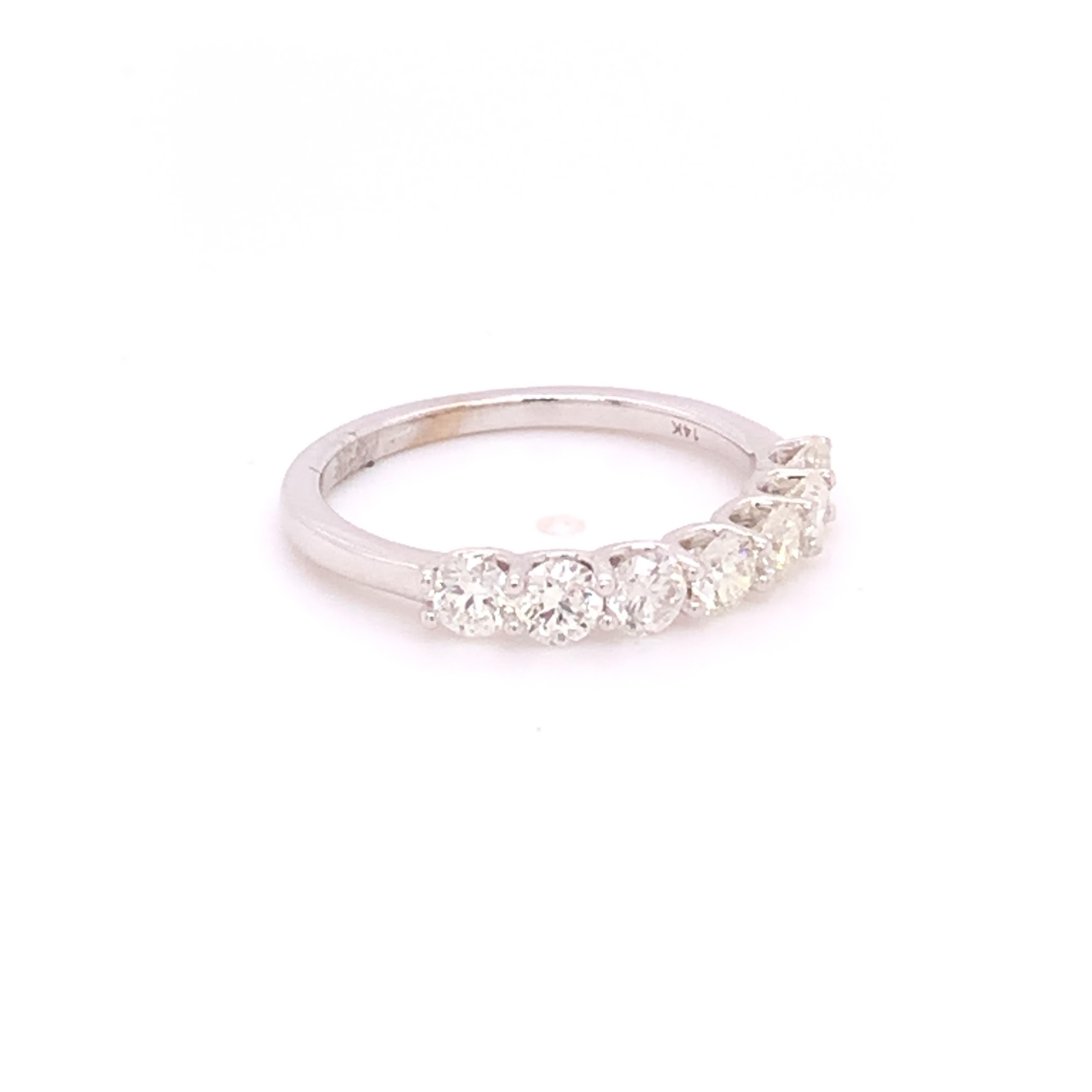 A beautiful timeless diamond band crafted in 14k white gold showcasing a total of 7 prong set round brilliant diamonds - 1 carat total weight. This luxurious band will sparkle in any light from every angle! This band can be matched with any type of