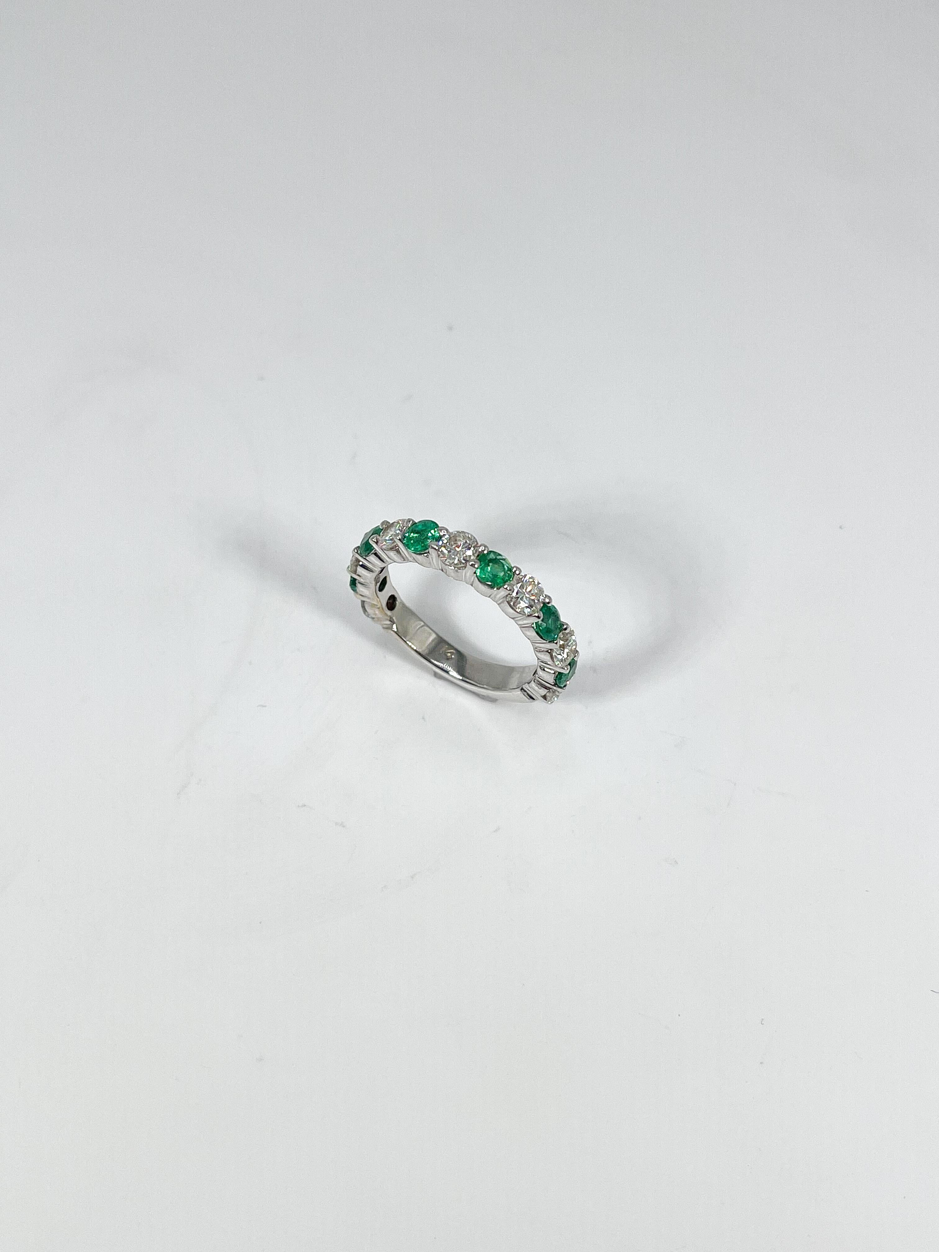 14k white gold 1 CTW diamond and 1 CTW Emerald anniversary band. The stones in this ring are all round, the ring size is a 5 1/4, the width is 3.5 mm, and it has a total weight of 4.1 grams.