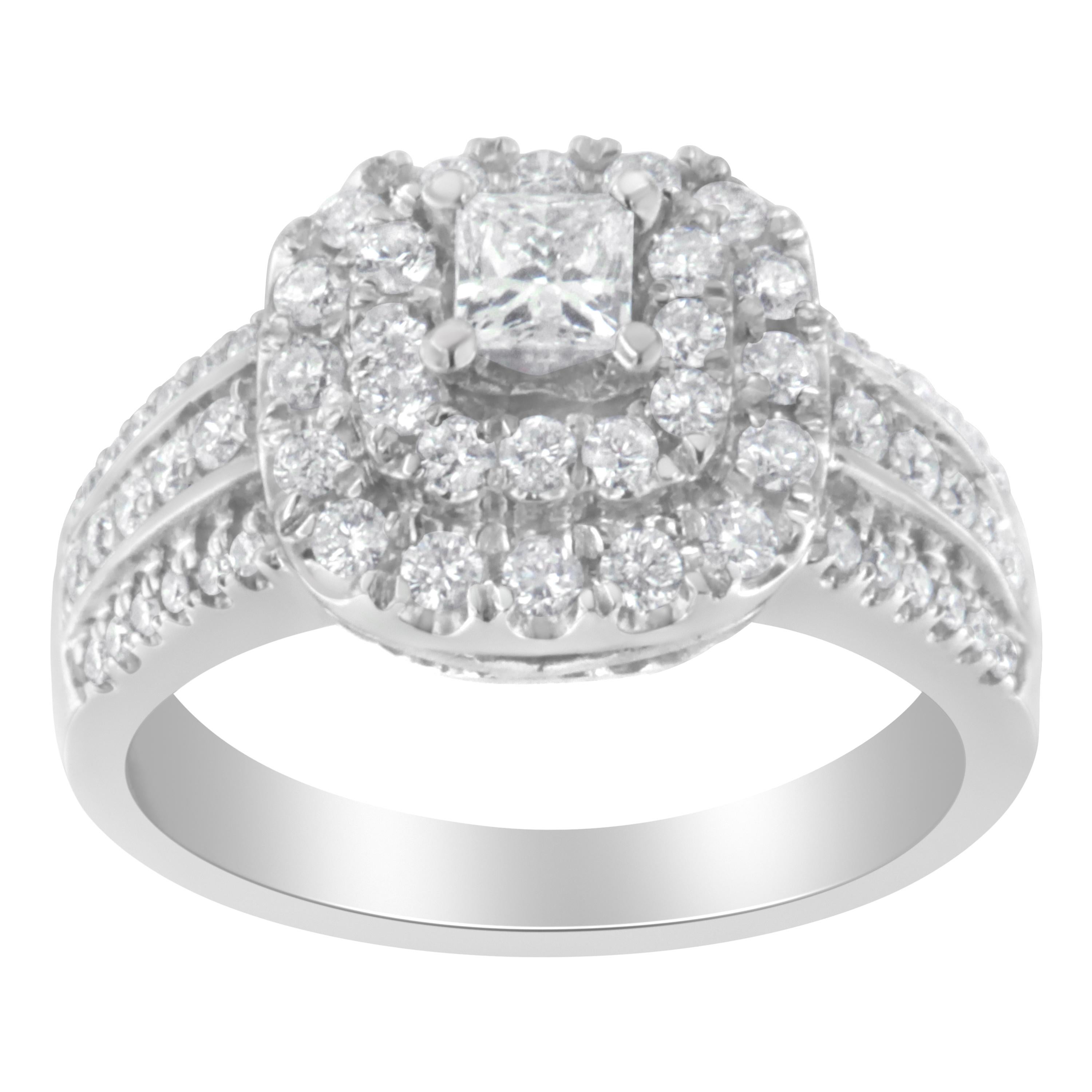 A diamond cluster ring that glimmers with a central princess cut diamond surrounded by a double halo of round diamonds. The wide band is crafted in 14 karat white gold and sparkles with three rows of round diamonds. The total diamond weight is 1