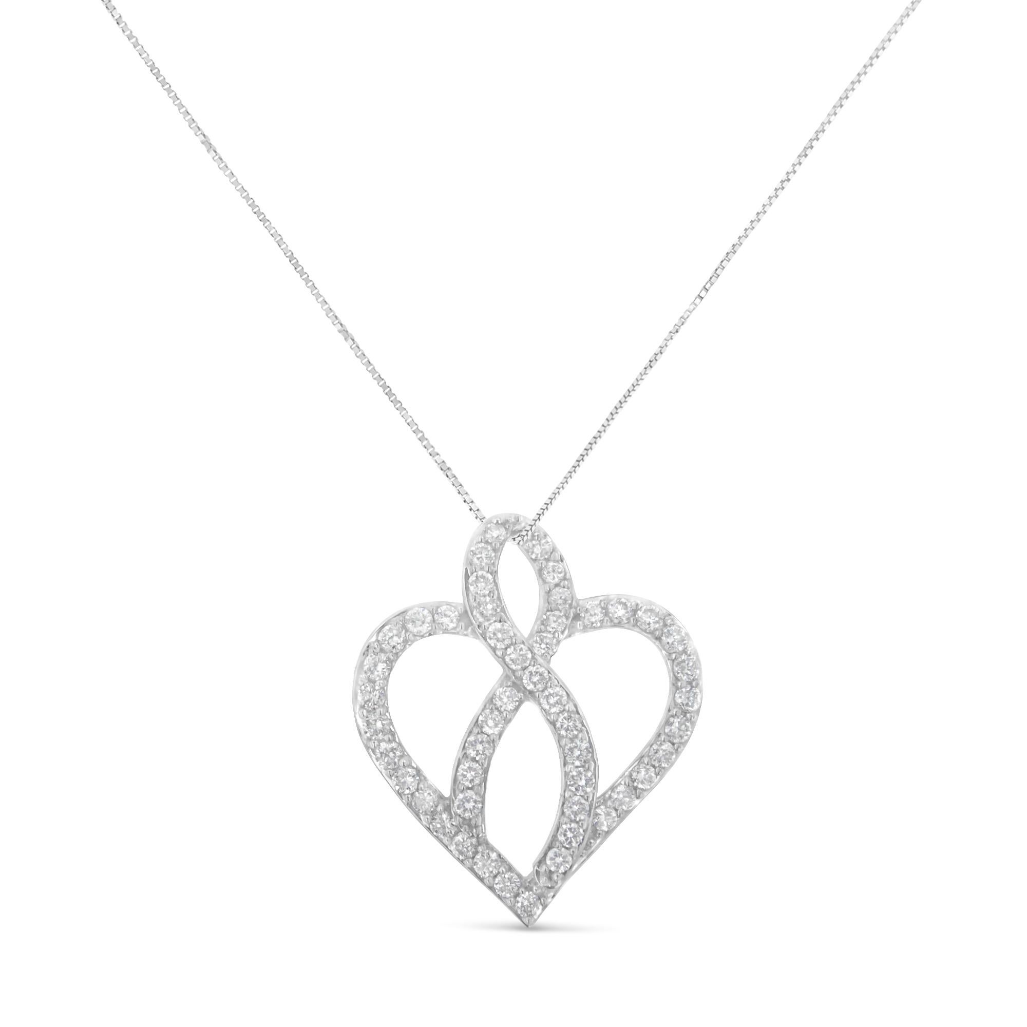 This lovely 14k white gold heart pendant necklace features 1 carat of beautiful, natural diamonds. The heart is intersected with a ribbon at its center, and both motifs are embellished with round-cut diamonds in an elegant prong setting. This