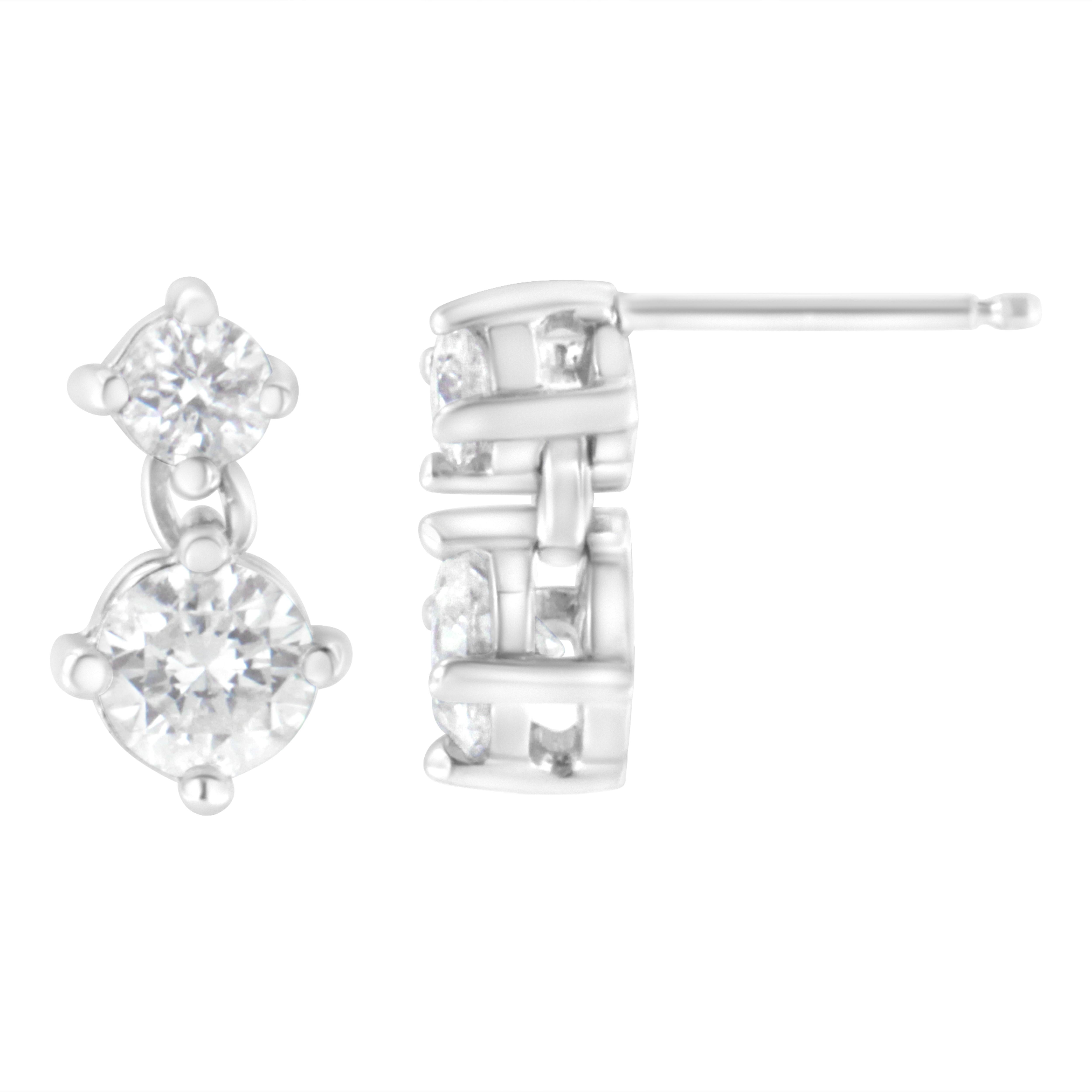 Accent your look with this chic pair of stud earrings. Composed of precious 14k white gold, these gorgeous earrings are finely burnished to shine. Further, the embellishment with flickering round cut diamonds in a prong setting giving this piece a