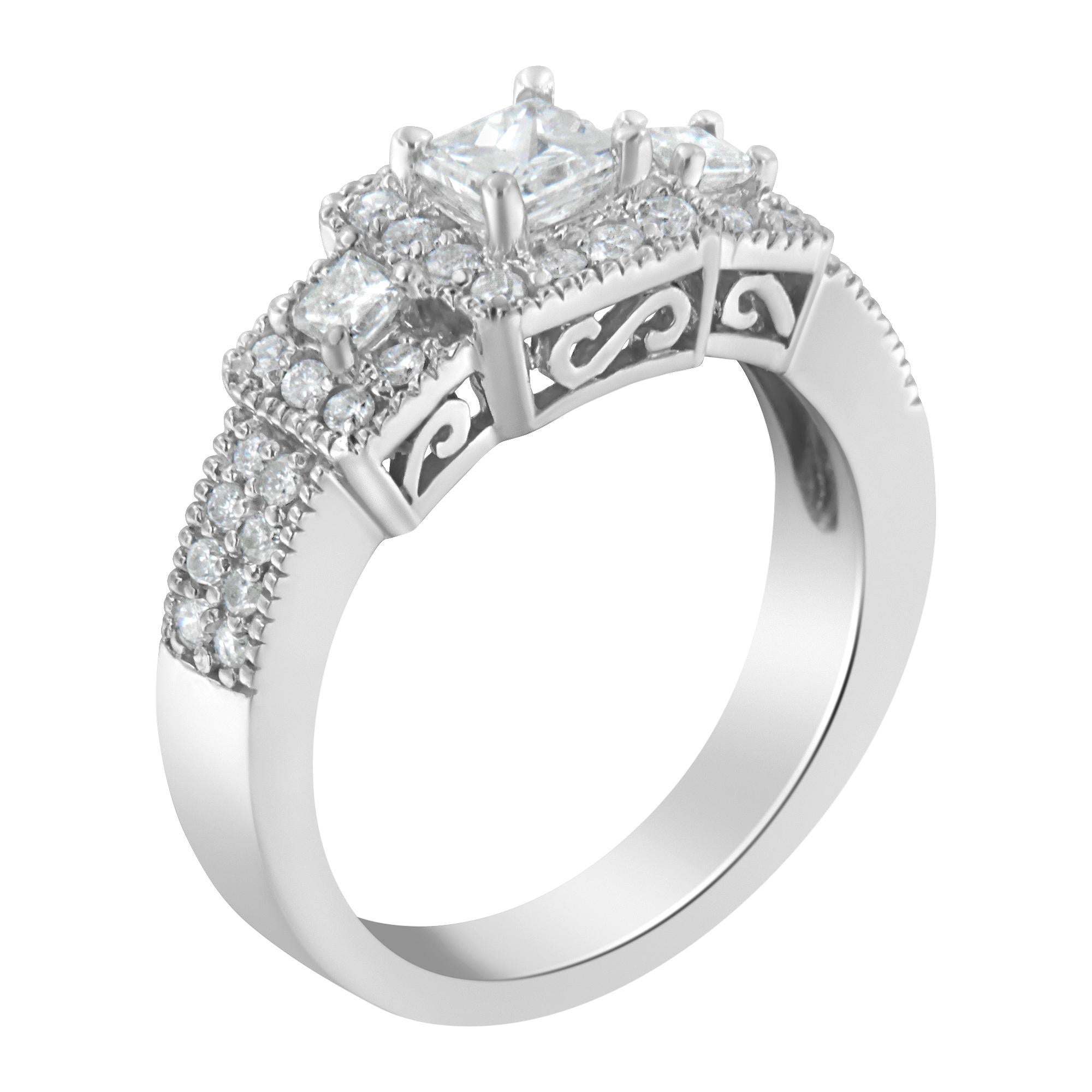 Un anello di fidanzamento in oro bianco 14 carati con tre pietre e tre diamanti taglio princess circondati da un'aureola di diamanti rotondi. La bordatura a grana grossa circonda questo disegno aggiungendo un tocco di stile vintage a questo design