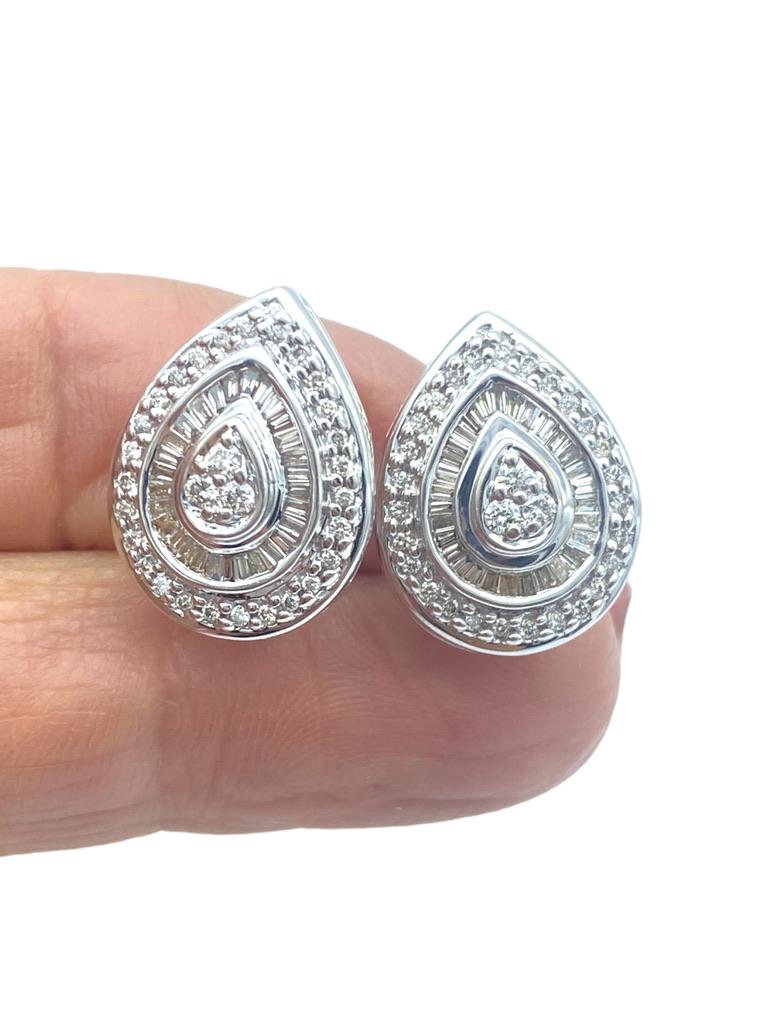 Impressive, pear shaped diamond halo diamond earrings are measured as .80 inch x .60 inches wide. The diamonds centered in earrings are a cluster of round diamonds surrounded by baguette cuts and still followed by a third row of round pave set