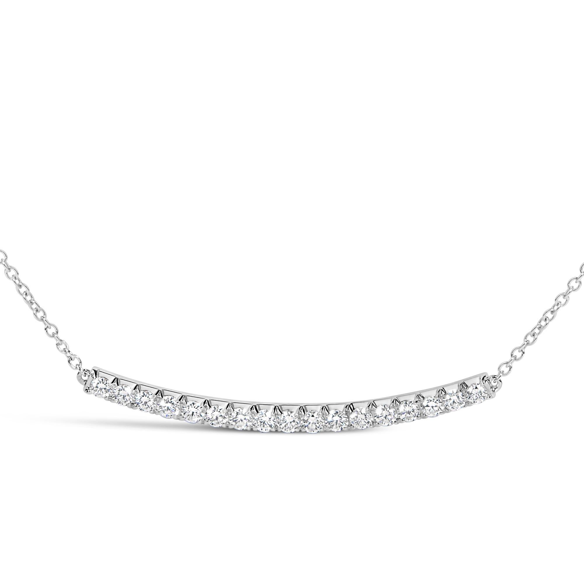 Sumérgete en el lujo con este exquisito collar colgante de barra curva de oro blanco de 14 quilates, brillantemente adornado con 17 diamantes naturales que en conjunto irradian un brillo cautivador. Cada gema, meticulosamente engastada con cuatro