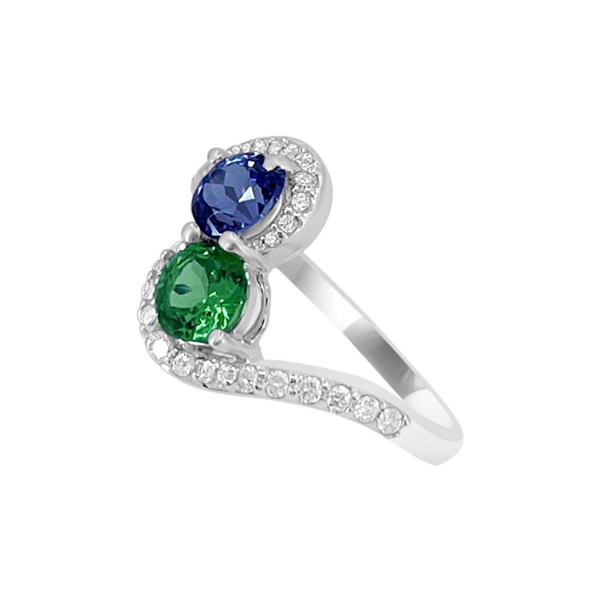 This Attractive Piece Of Jewelry With Two Center Stone Of 5mm Tanzanite And Emerald Sits Atop With Pave Set Diamonds Band To Embrace The Larger Stones. This Design Is Truly Unique And Luxurious Made Of 14K White Gold. Its A Timeless Look That Will