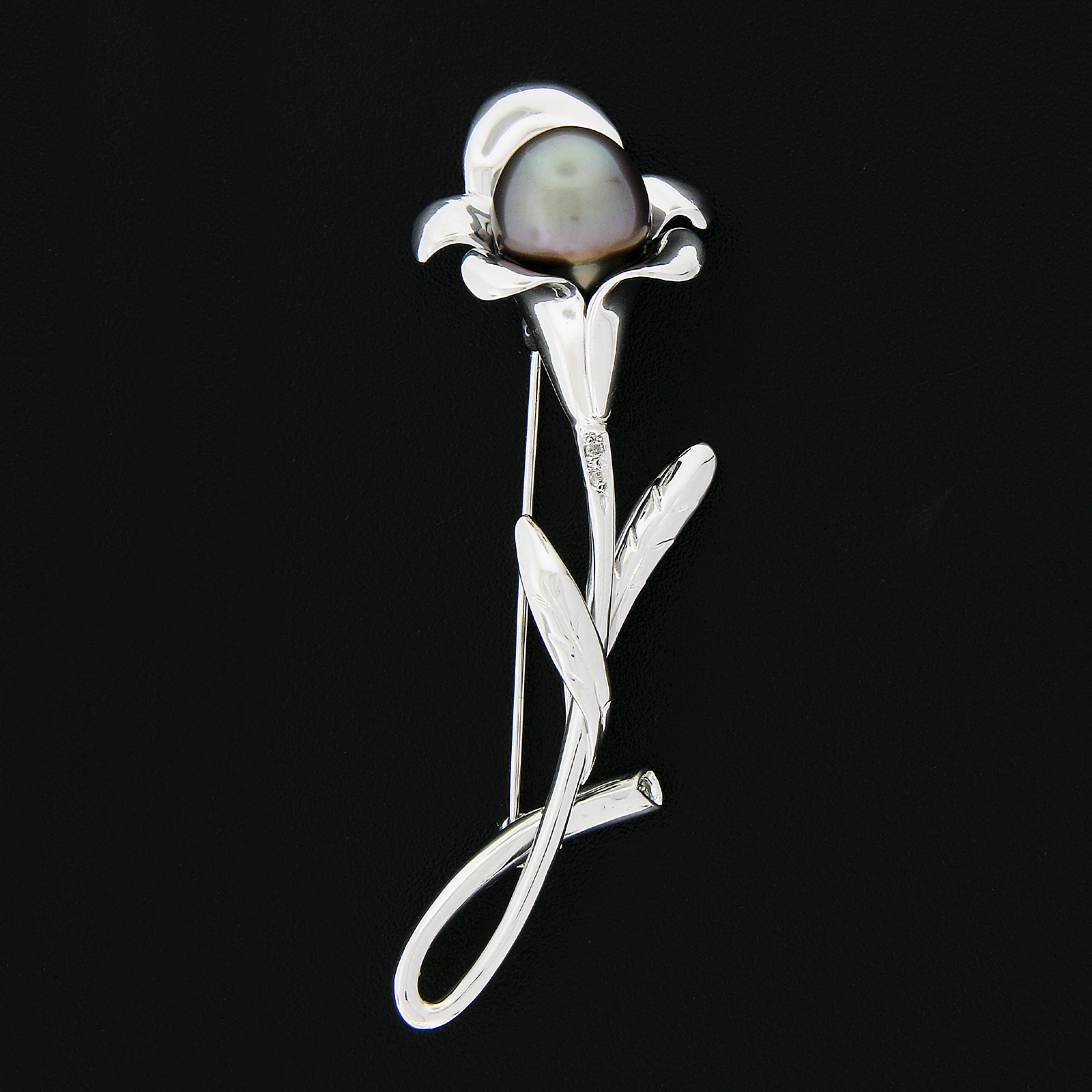 Here we have a wonderful pin/brooch that was crafted from solid 14k white gold featuring a beautiful flower design. Neatly set in the center is a fine Tahitian pearl. The round brilliant diamonds are pave set enhancing the brooch with wonderful