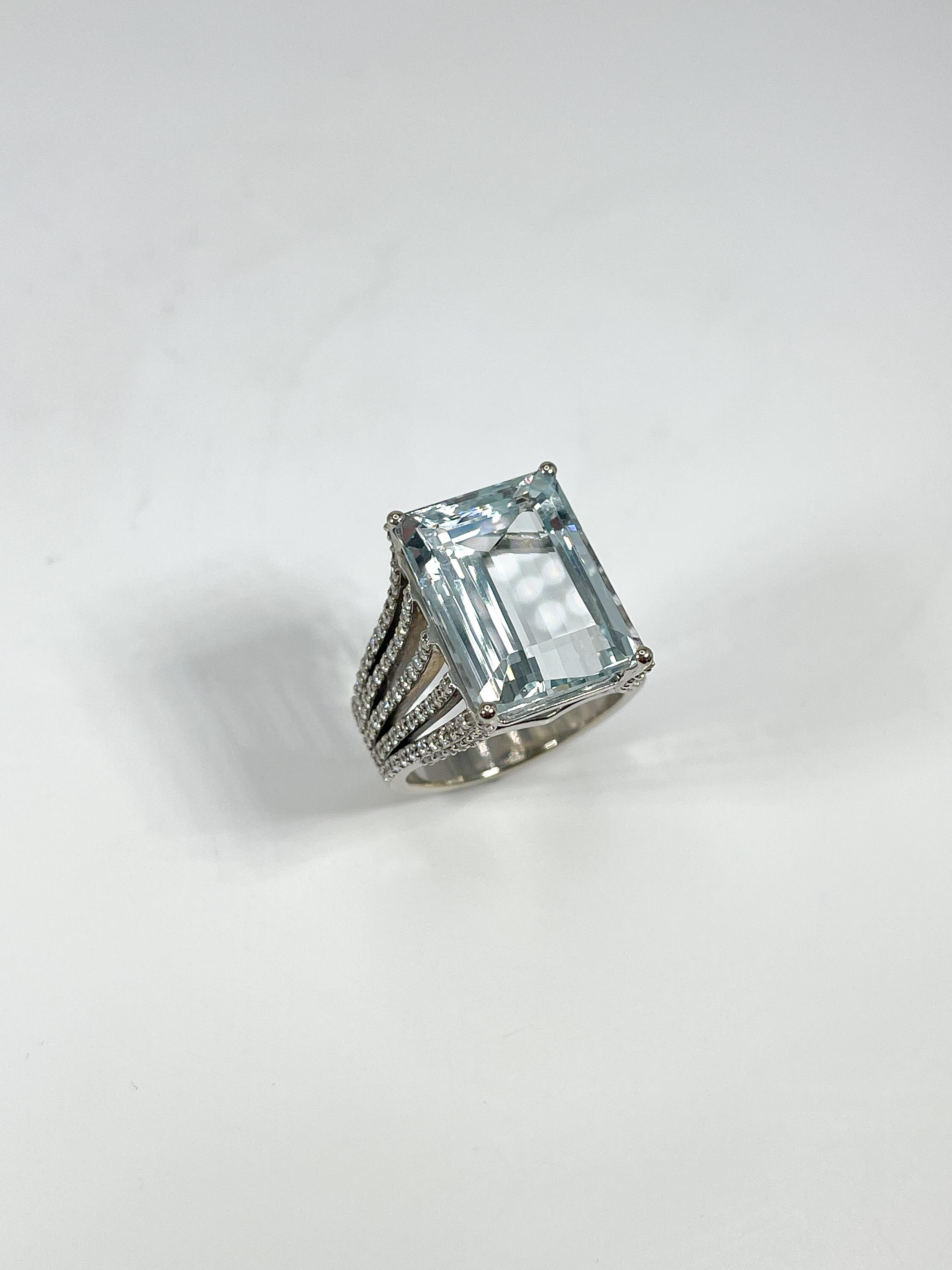 14k white gold fashion ring with 11 CTW emerald cut aquamarine center stone and 5 rows of diamond side stones 1.50 CTW. Center stone measures 16.3 x 12.2 mm. Ring is a size 7 and has a total weight of 10.9 grams. 