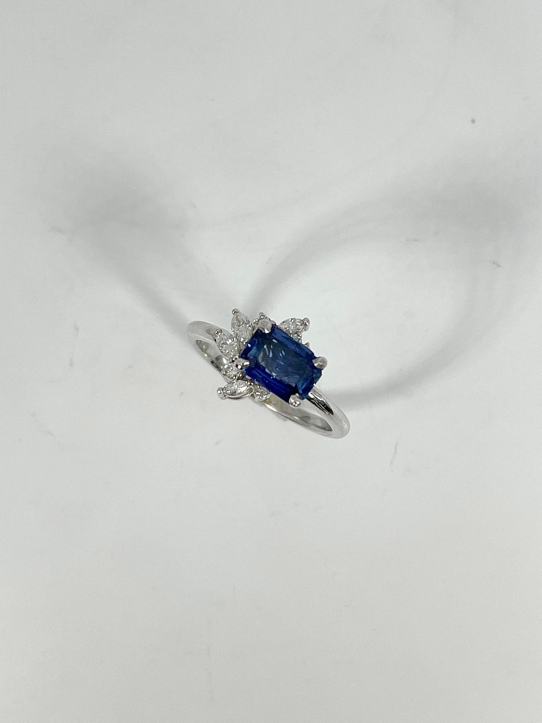 14k white gold 1.21 Ct sapphire and diamond fashion ring. Center stone is a radiant cut sapphire going east to west along with marquise and round diamonds in a design around the sapphire. The ring is a size 6 1/2 and has a weight of 3.14 grams.
