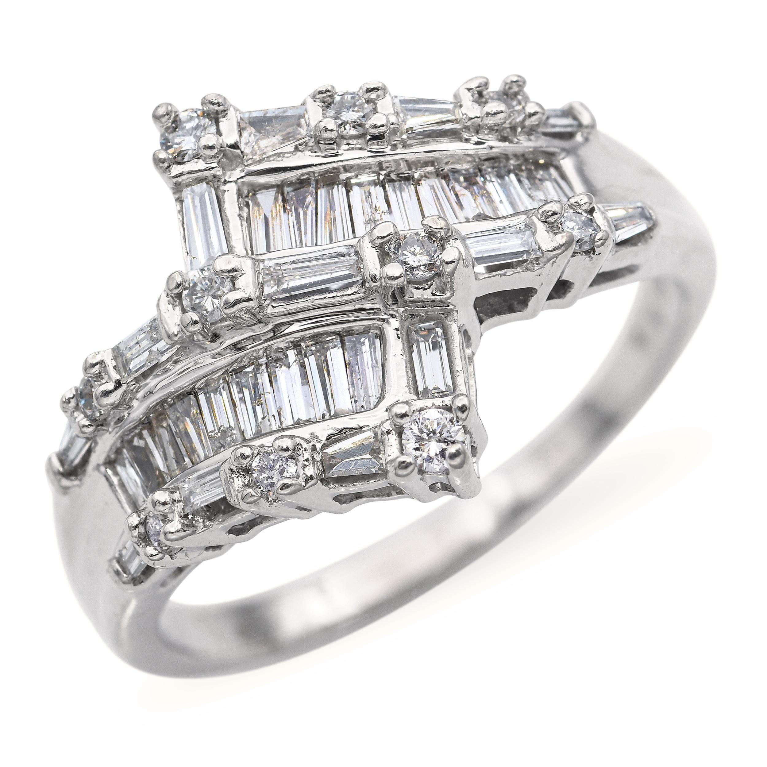 Cette élégante bague vintage présente un élégant design semi-bypass, orné d'environ 1,25 carats de diamants taille baguette étincelants. Les diamants sont sertis en canal le long des épaules, suivant gracieusement la courbe de chaque pontage pour