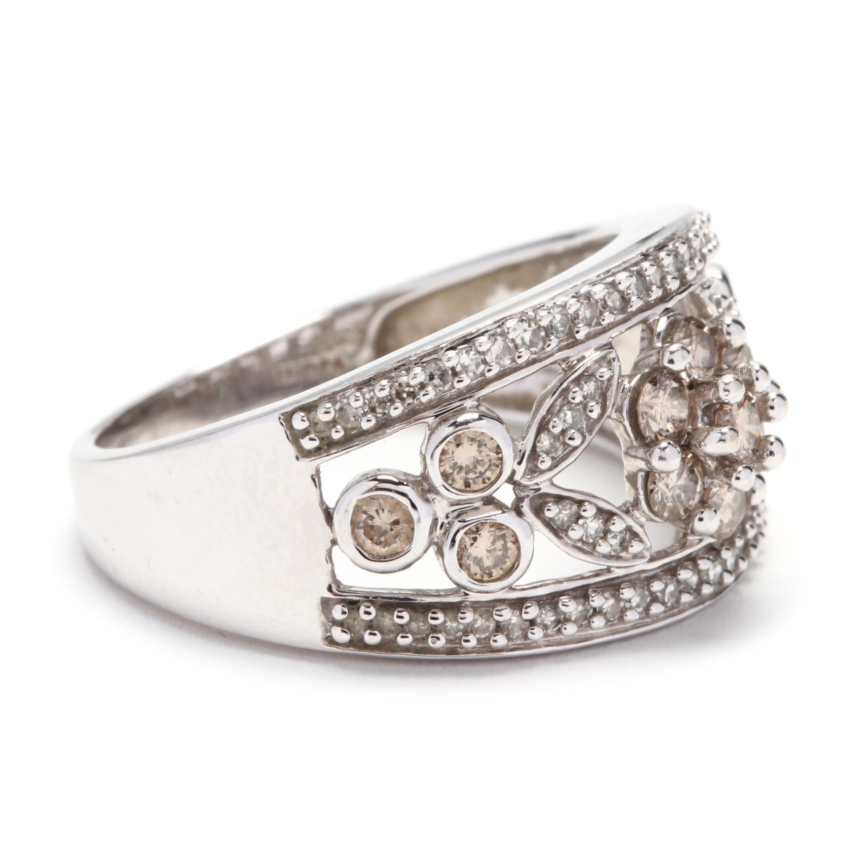 A 14 karat white gold, brown and white diamond wide flower band ring. This ring features a tapered wide band design with an open floral motif in the center with colorless and light brown round cut diamonds weighing approximately 1.27 total carats