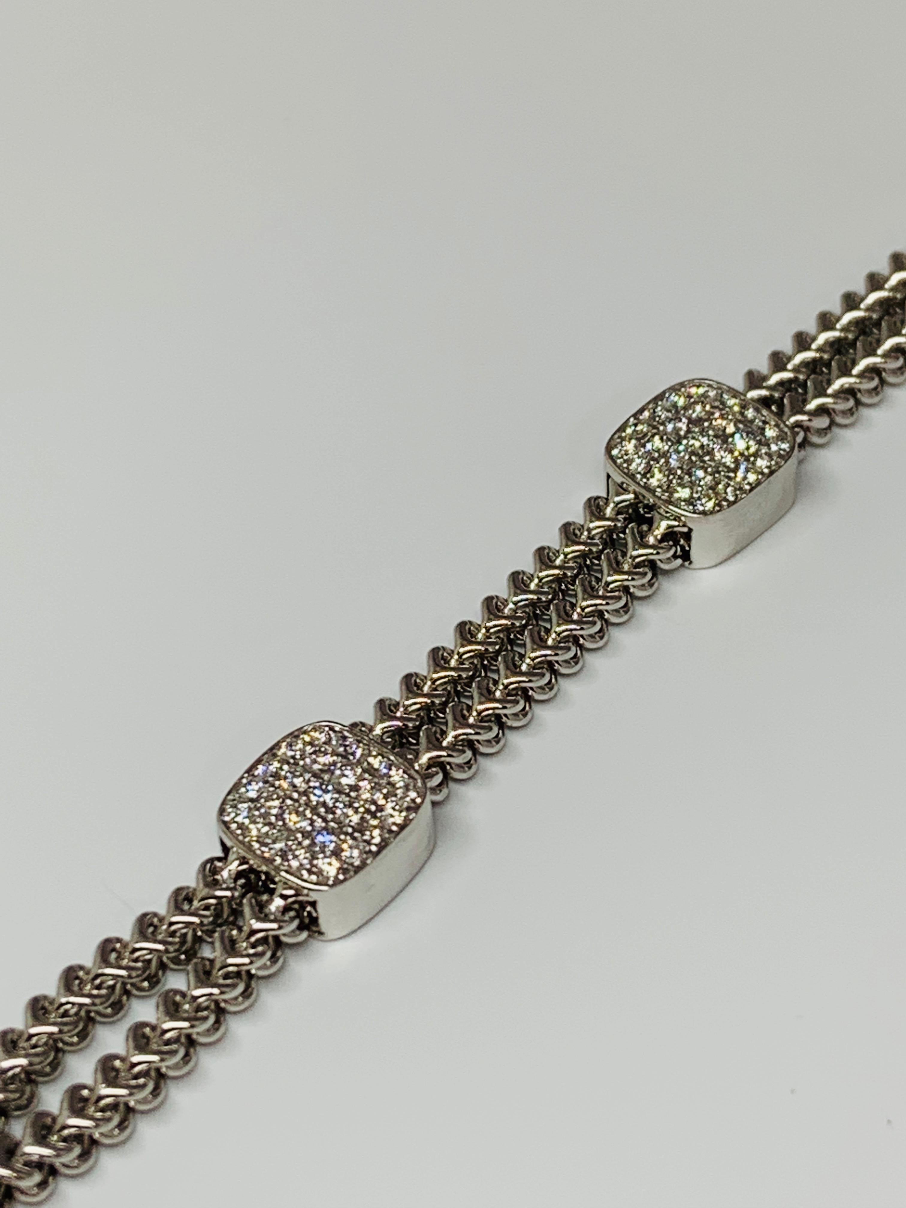 This unique piece features five diamond cluster stations on a double chain bracelet. The double chain provides incredible comfort during wear time and includes a sturdy box clasp. The diamond stations total 1.50 carats of round white diamonds. This