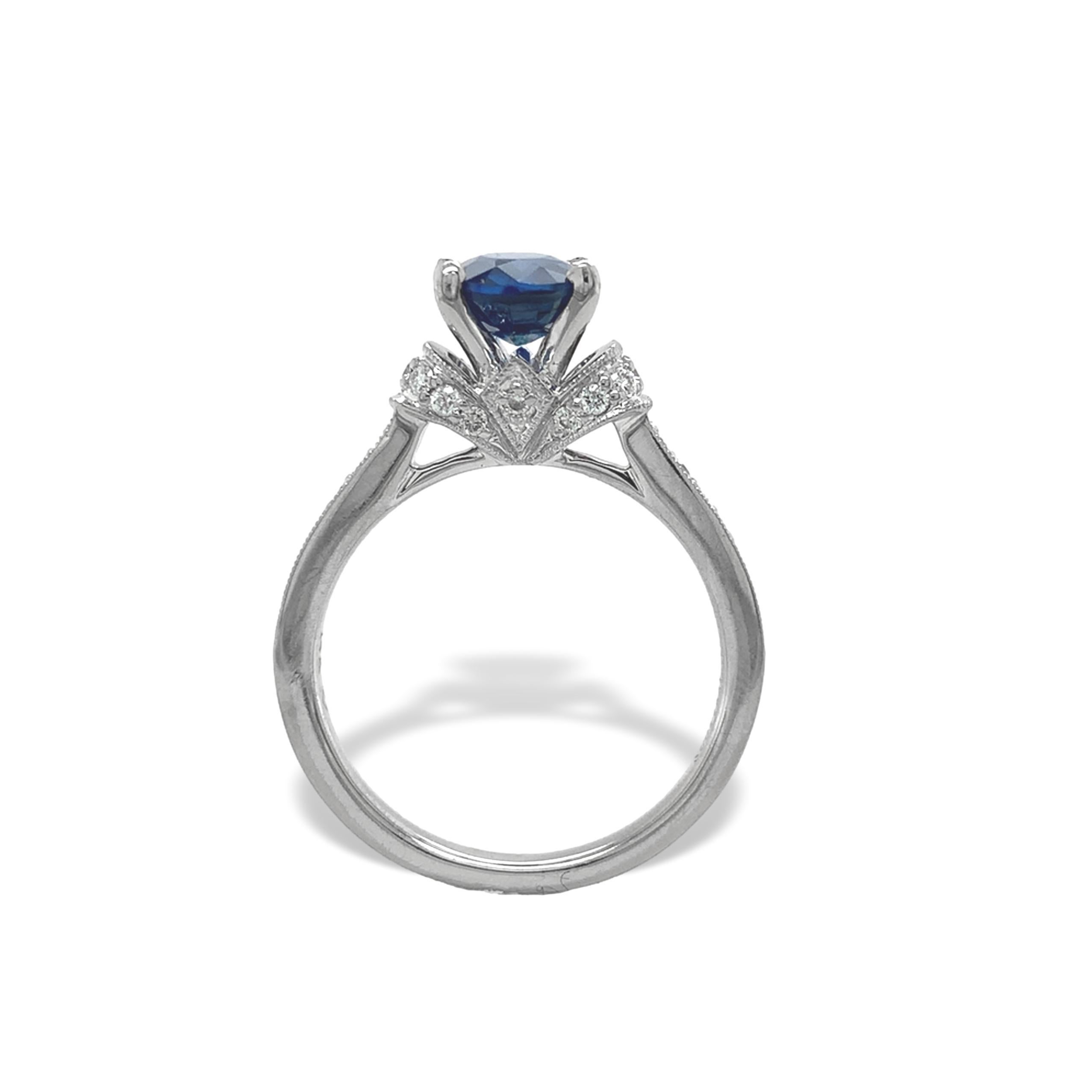 Anillo de oro blanco de 14 quilates de zafiro y diamantes con un zafiro azul ovalado de 1,74 quilates. El zafiro azul auténtico extraído de la tierra es de color azul marino y mide unos 8 mm x 6,2 mm.  Acentúan el zafiro 30 pequeños diamantes