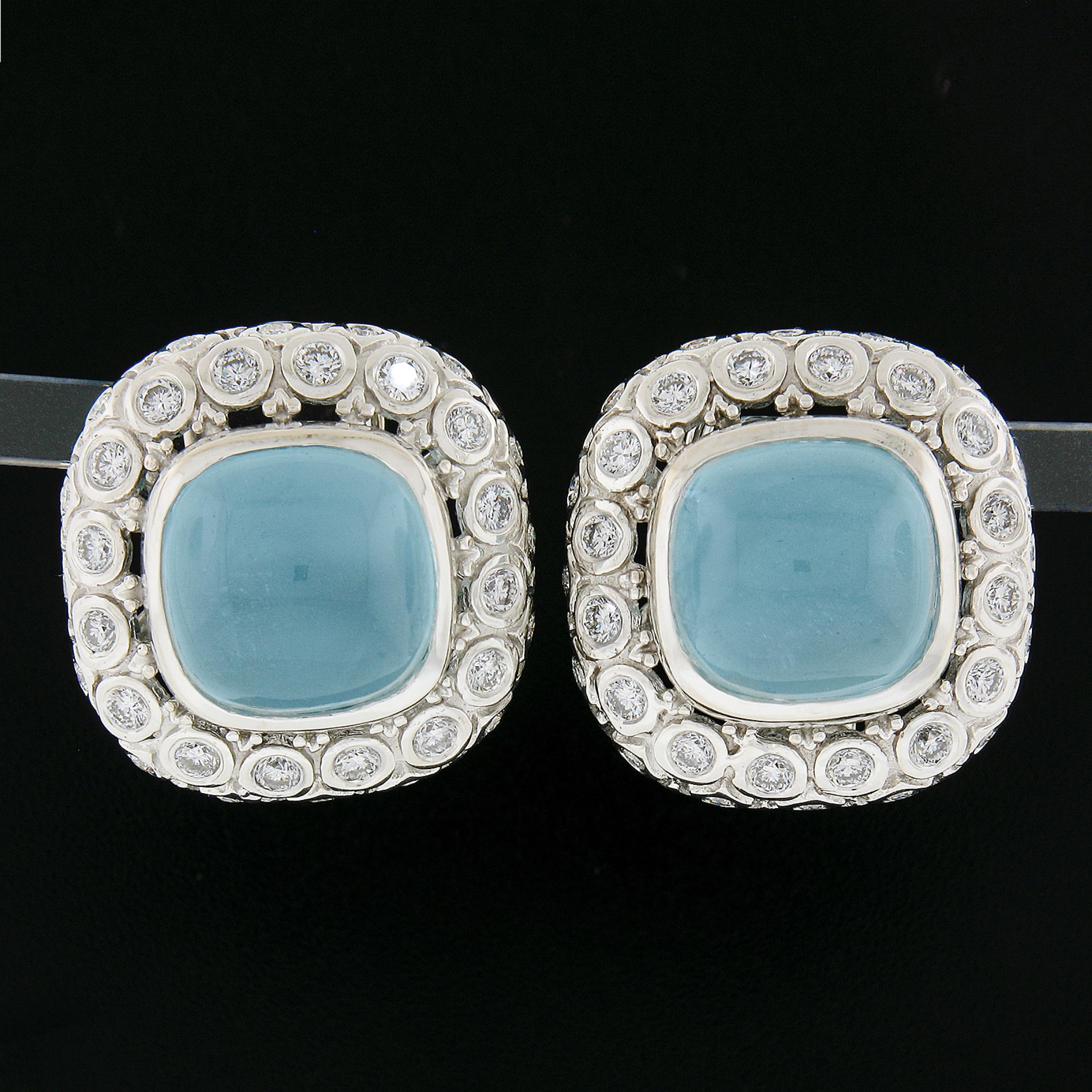 --Stone(s):--
(2) Natural Genuine Aquamarines - Cushion Cabochon Cut - Bezel Set - Light to Medium Blue Color w/ Natural Inclusions - 12.5x12.5mm (approx.) - 18ctw (approx.)
(64) Natural Genuine Diamonds - Round Brilliant Cut - Bezel Set - G-I Color