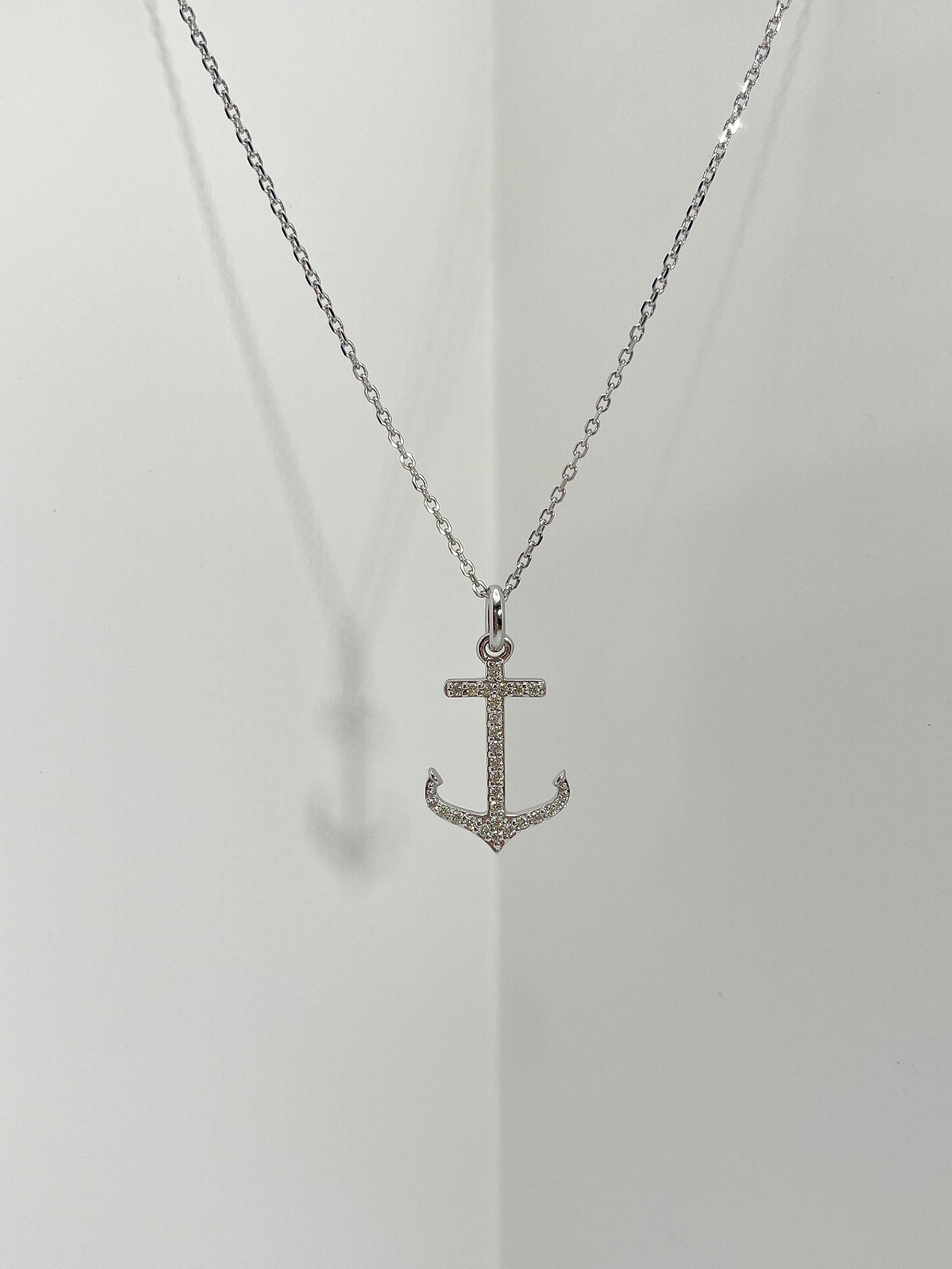 14k white gold .25 CTW diamond anchor pendant necklace. All diamonds in the pendant are round, the pendant measures 23mm x 14.5mm, comes on an 18-inch diamond cut cable chain, has a lobster clasp to open and close, and has a total weight of 4 grams.