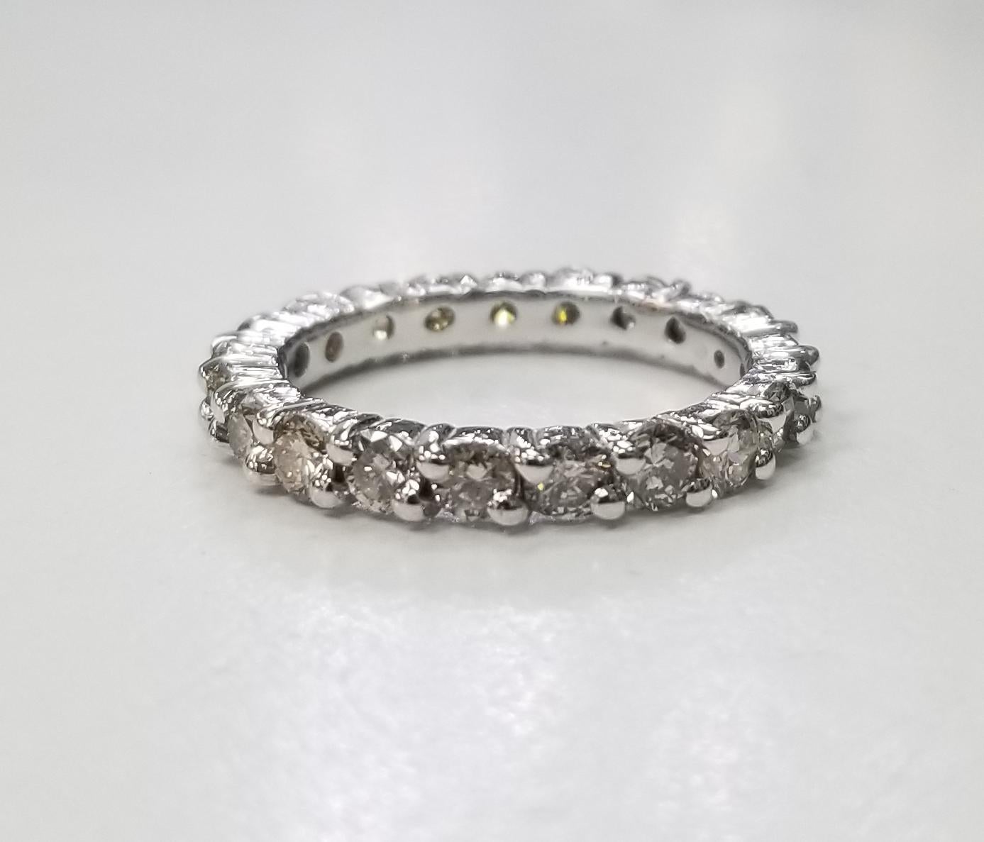14k white gold 2.8mm wide Diamond eternity with shared prongs, ring with 2.12cts., containing 21 round full cut diamonds; color I, clarity VS and weight 2.12cts. ring is a size 6.25.