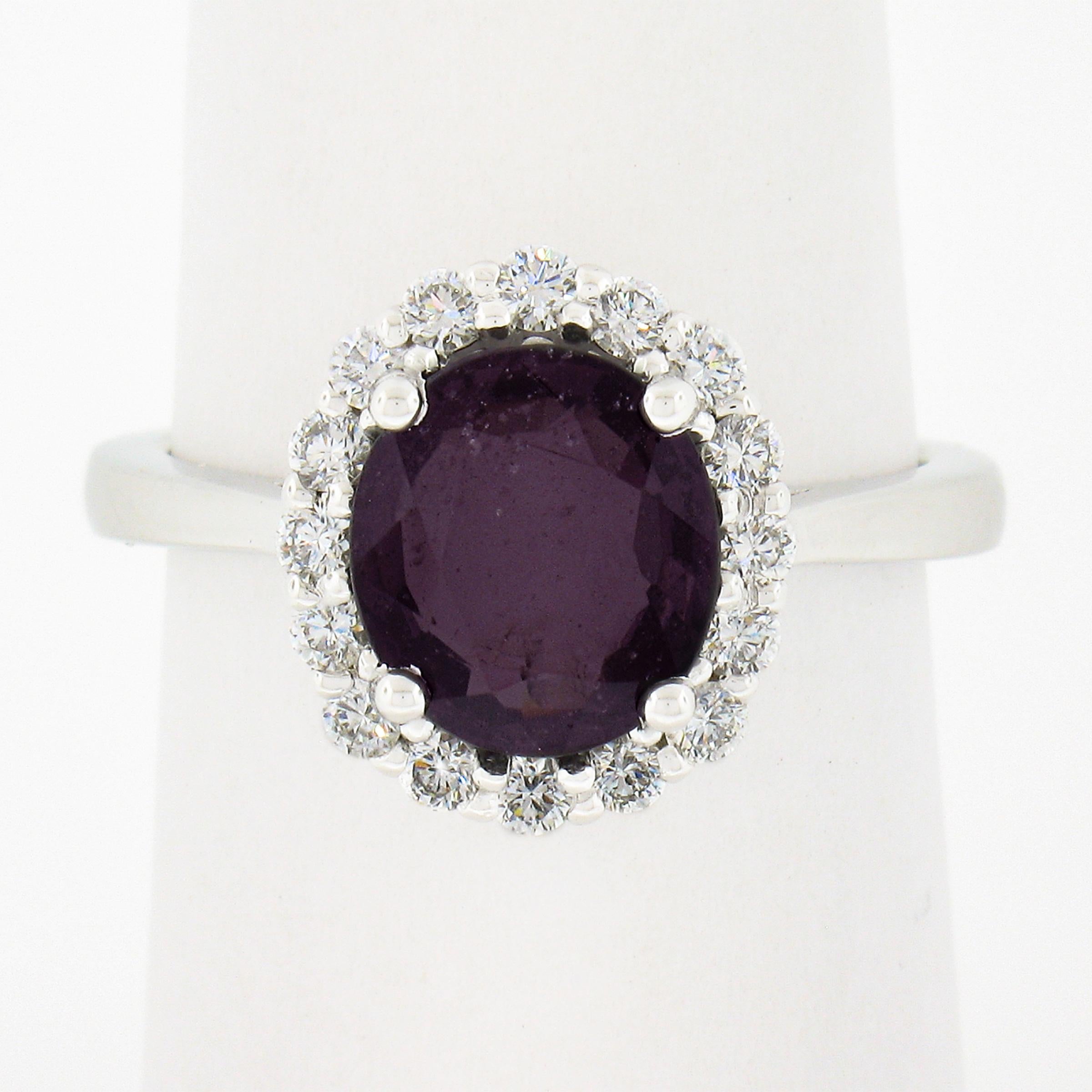 This unique and well made spinel and diamond halo ring is newly crafted in solid 14k white gold and features a wonderful, 2.52 carat deep purple spinel that is GIA certified at being 100% natural genuine stone with no treatment of any sort. This