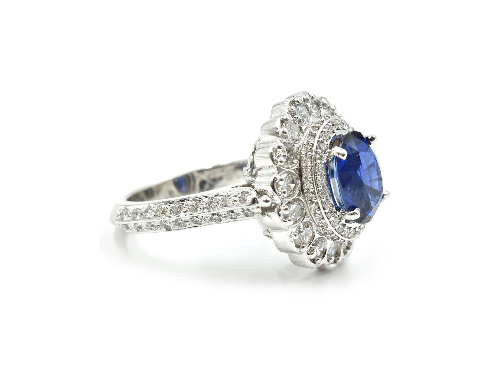 A modern 2.95ct blue sapphire cocktail ring! This untreated and unique blue sapphire has a gorgeous diamond halo and is set in an intricately-crafted mounting! The detailed shank is crafted from 14k white gold dual rows of diamonds set in the