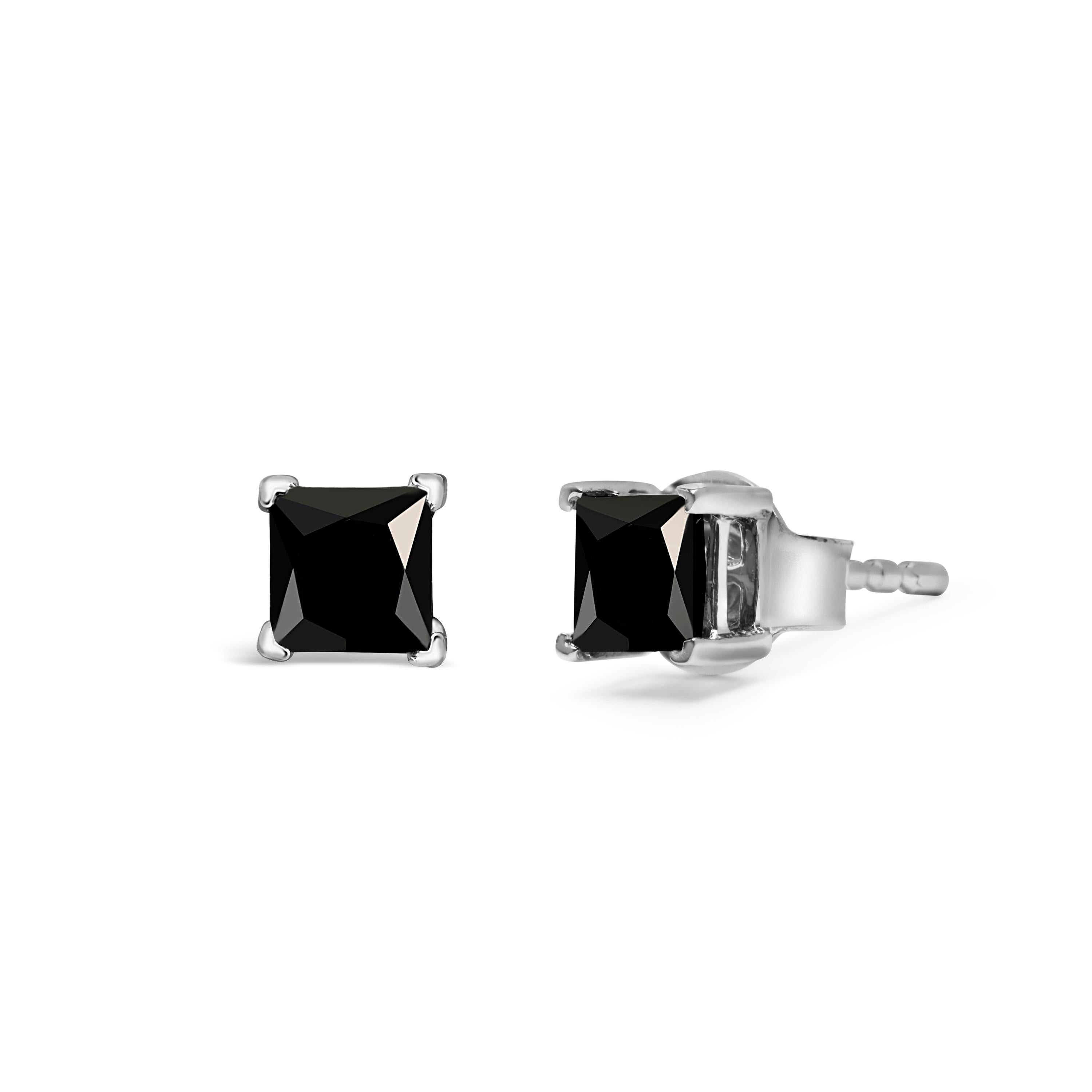 Indulge in the captivating allure of these classic princess-cut black diamond stud earrings. The two diamonds, weighing 3/4 cttw, have been treated to enhance their natural beauty, giving them a stunning black hue that is sure to turn heads. Set in