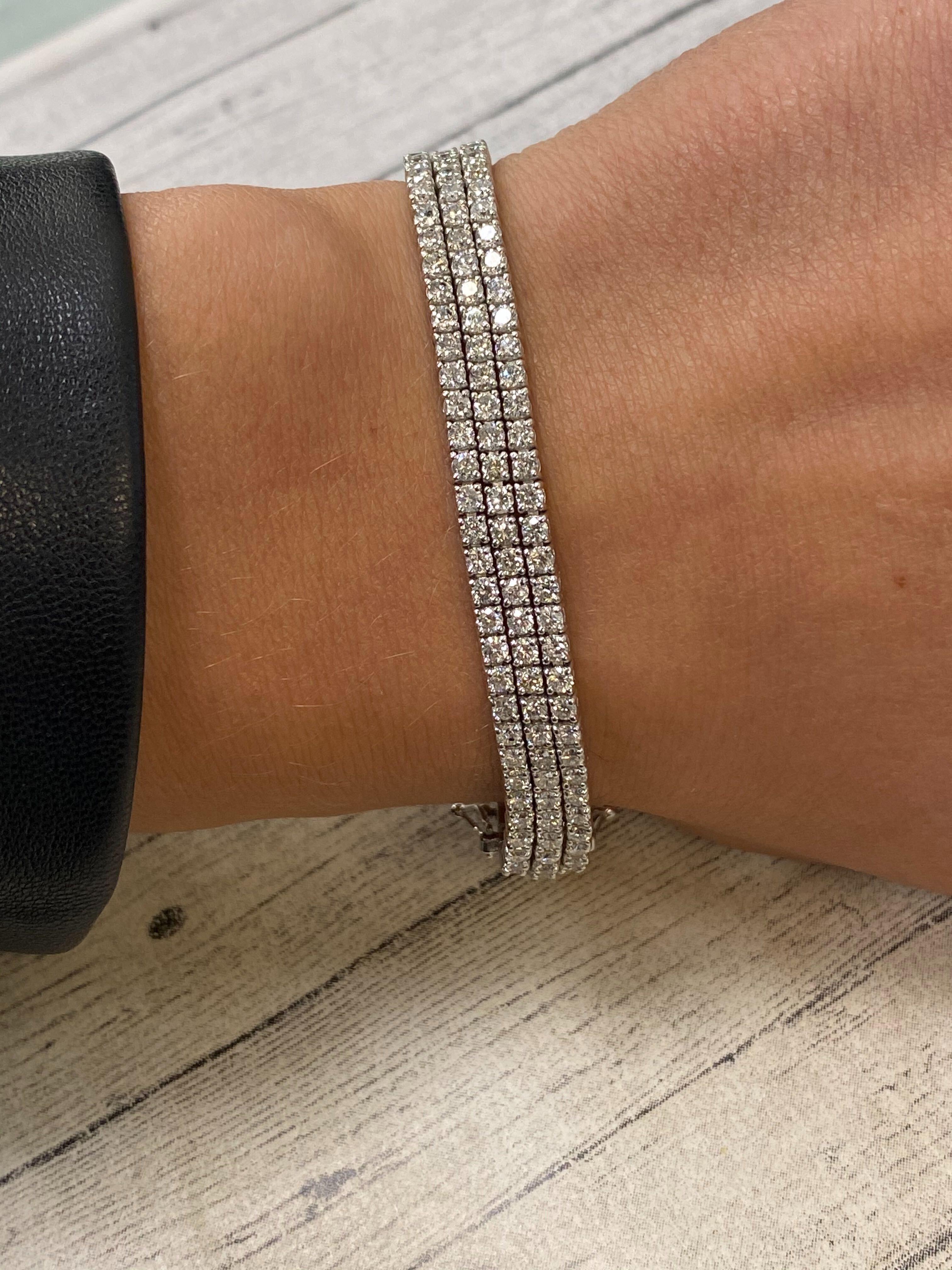 This fantastic white gold 3-row prong diamond bracelet showcases 12.60 carats of sparkling round cut diamonds. Each stone expertly set in a lustrous gold frame. Featuring a trendy 3-row, prong-set design and a flexible fit. 225 diamonds in