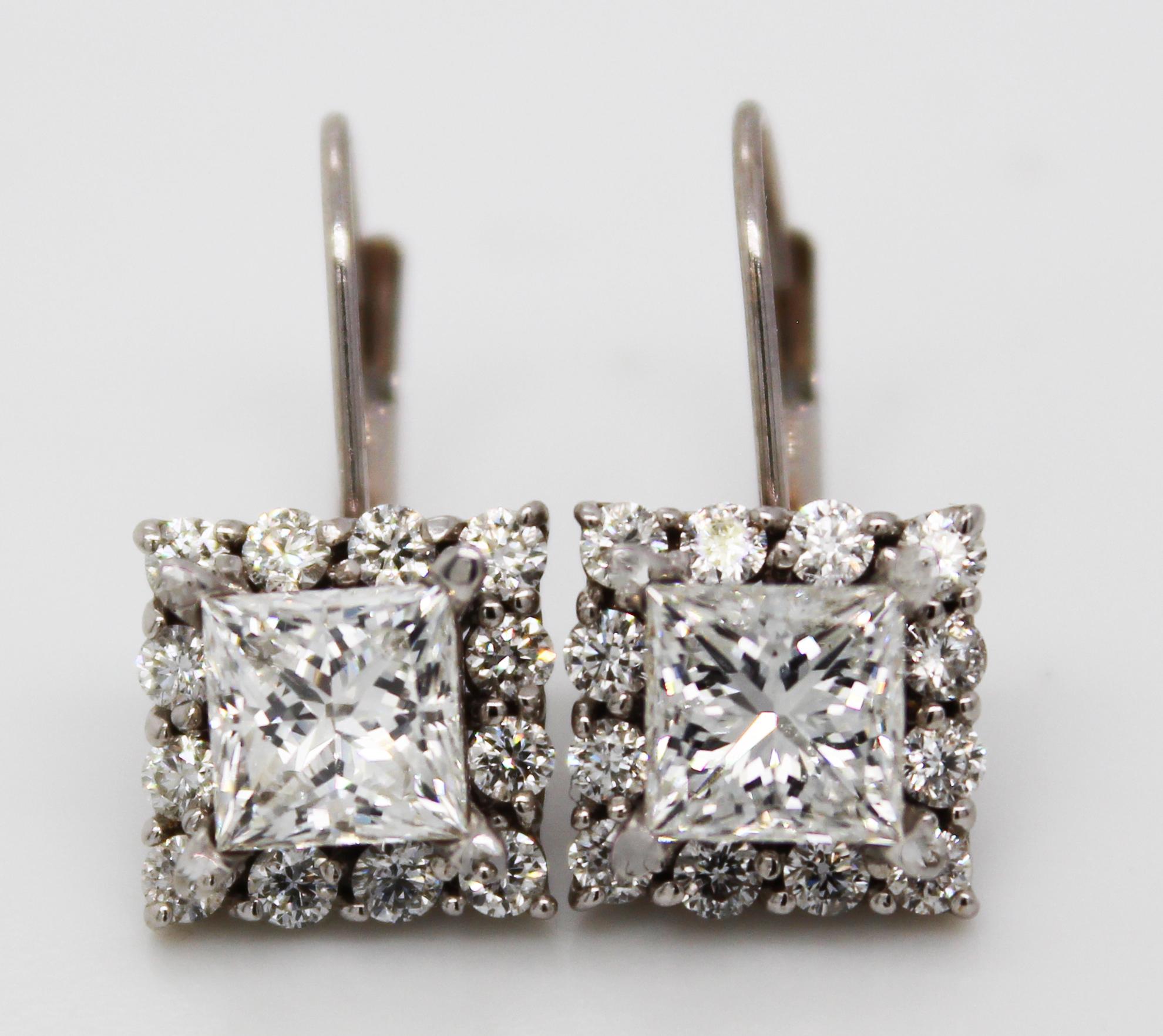 These incredible earrings are in 14k white gold and feature 3.00 carats of stunning, brilliant white diamonds! The gorgeous layout of these earrings feature a large princess cut diamond center surrounded by a frame of round diamonds. The layered