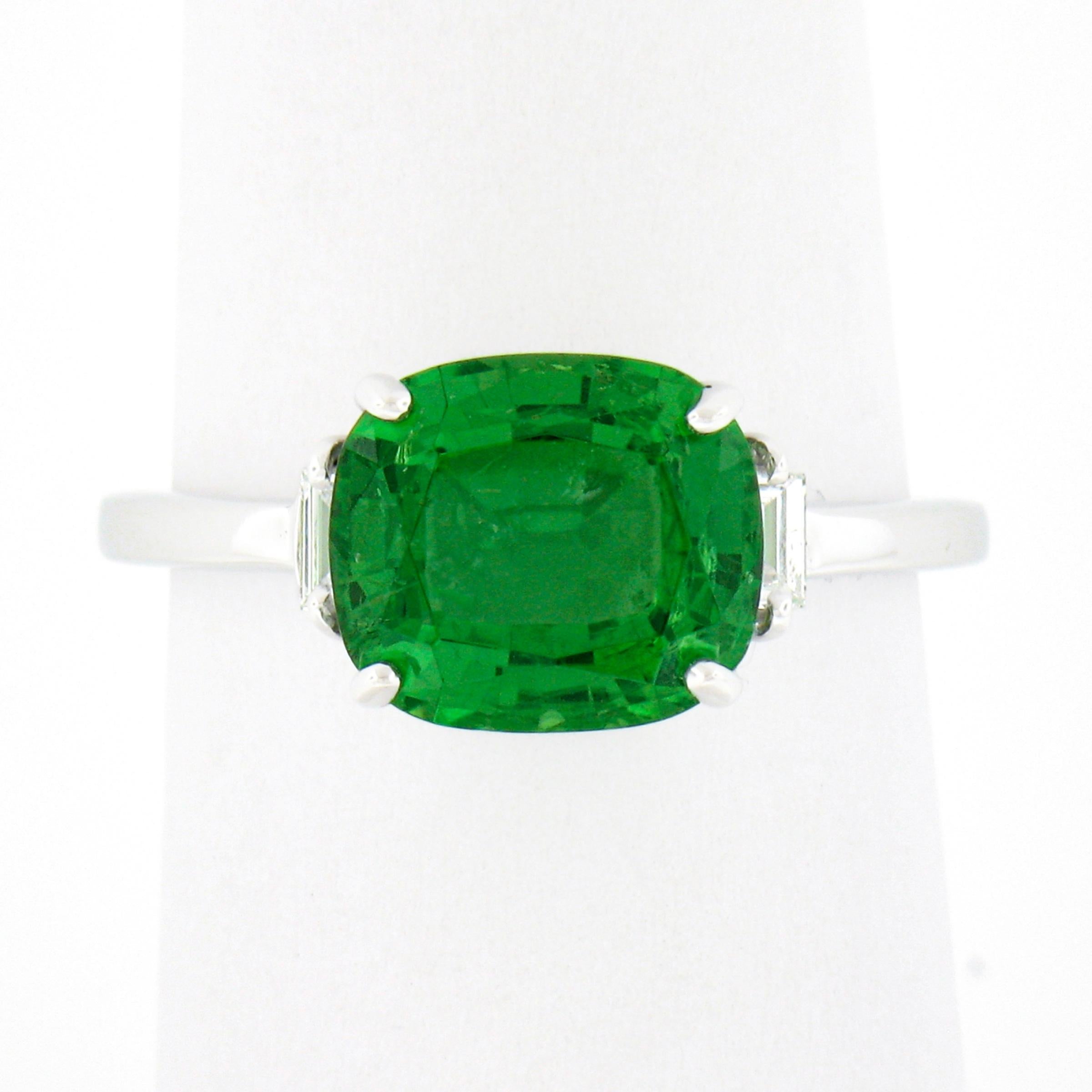 This stunning chrome tourmaline and diamond ring is crafted from solid 14k white gold. The ring features a breathtaking, natural, cushion cut tourmaline solitaire that is neatly set at the center displaying the finest and most desirable vivid green