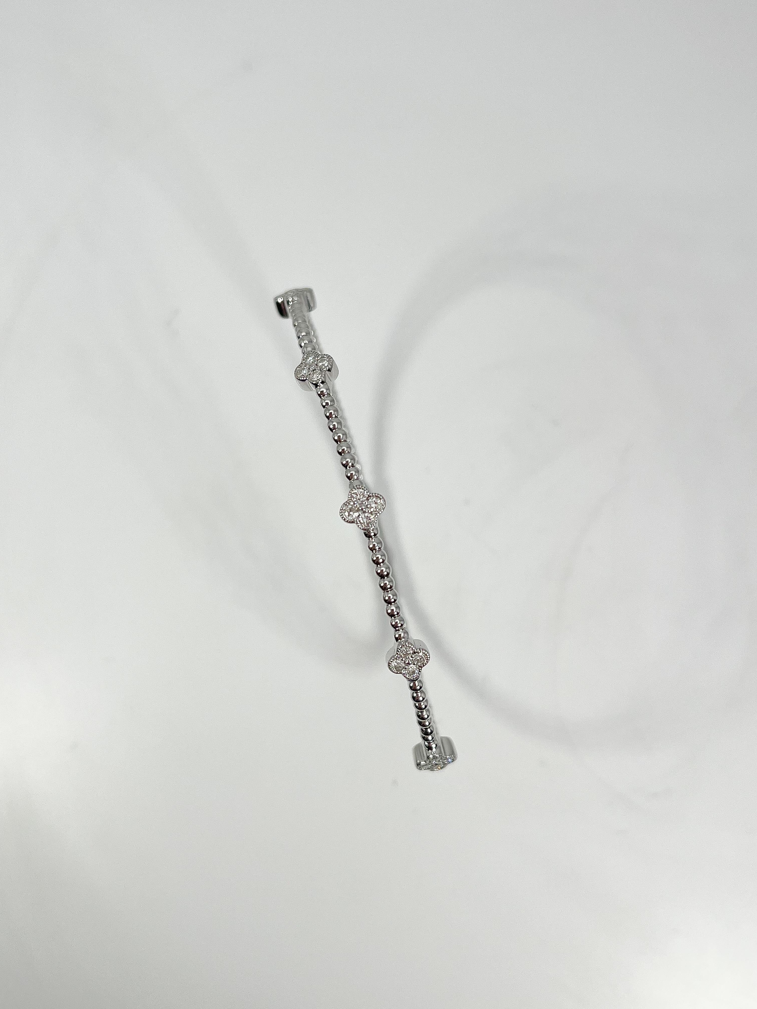 14k white gold .43 CTW diamond cluster bangle. The diamonds in this bangle are all round, will fit wrist no larger than 5 1/2 inches, has easy to open clasp, has a total weight of 5.1 grams.