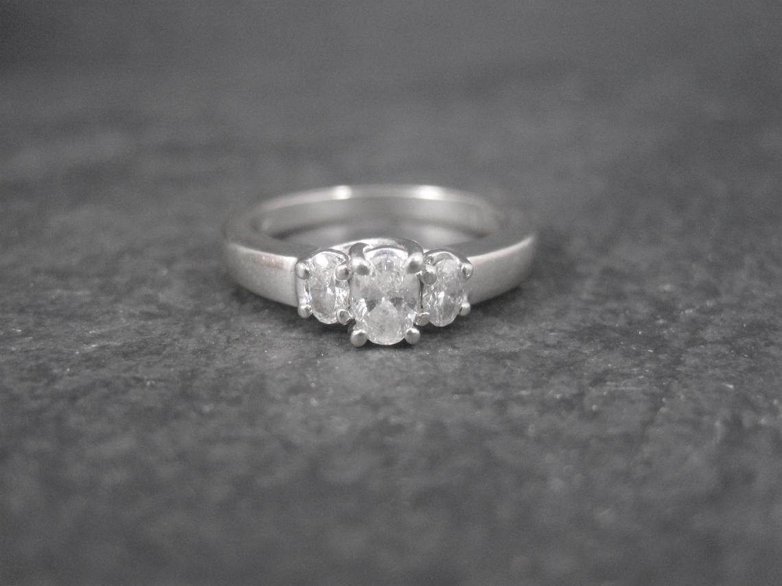 This beautiful 90s ring is 14k white gold.
It features 3 oval cut natural diamonds weighing .50 carats.

Diamonds are estimated to be G to H in color and SI2 in clarity.

The face of this ring measures 1/4 of an inch north to south with a rise of