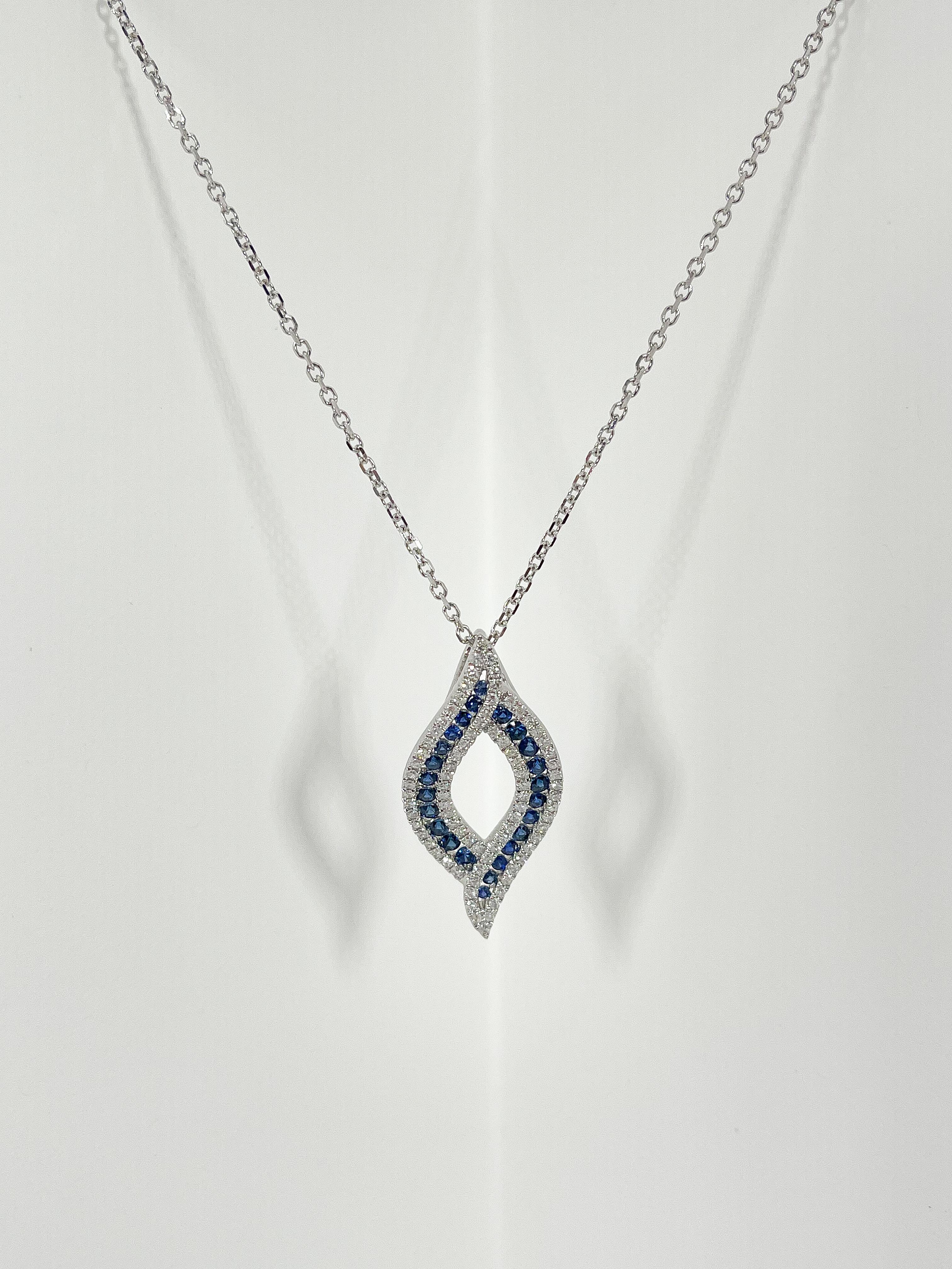 14k white gold .57 CTW diamond and .78 CTW sapphire pendant necklace. The stones in the pendant are all round, the pendant comes on a cable chain, the measurements of the pendant are 32.3 x 15.7 mm, the length of the necklace is 18 inches, and it