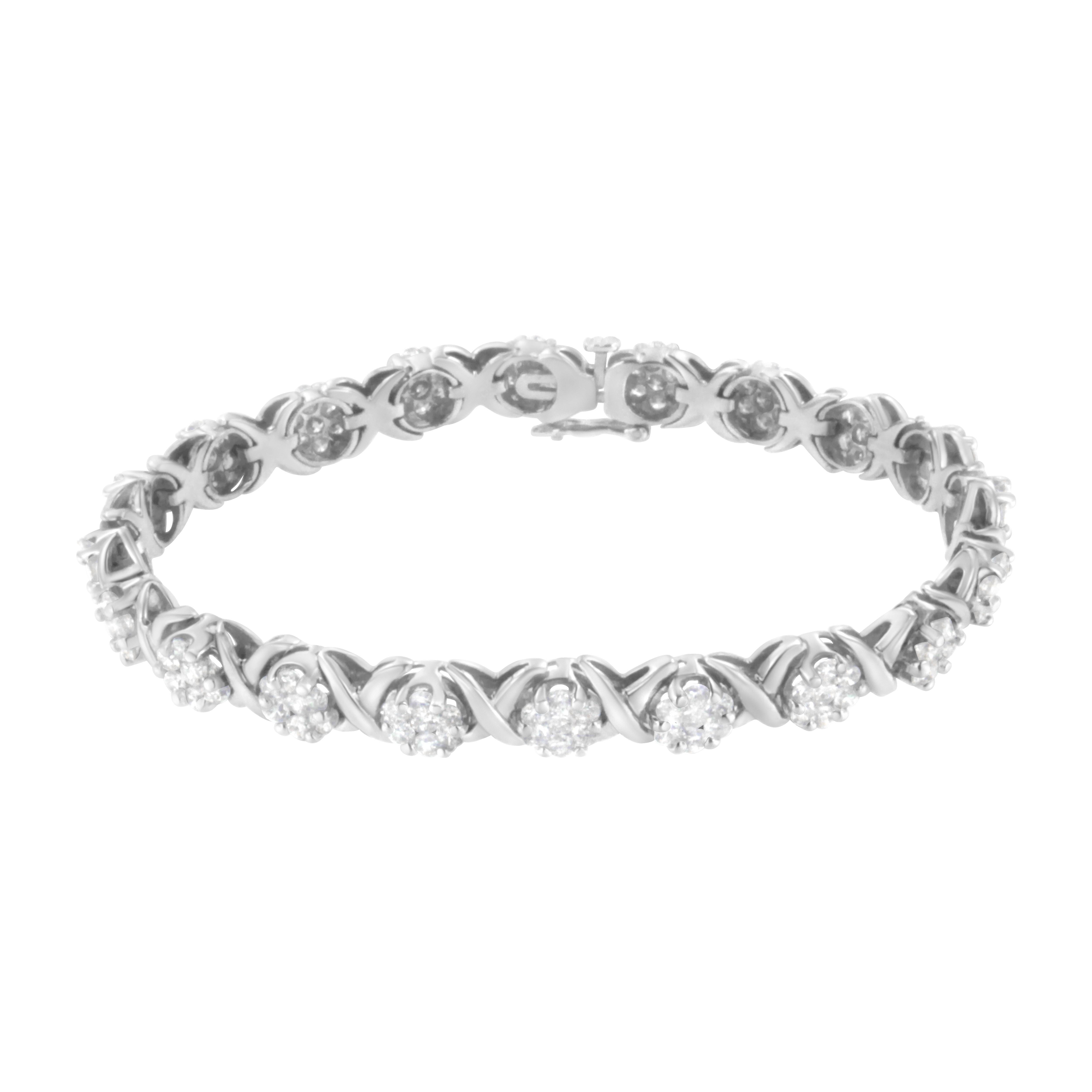 Elegant and timeless, this gorgeous 14K white gold tennis bracelet features alternating links with round clusters of brilliant cut diamonds and X shaped links. The tennis bracelet closes with a box clasp with foldover figure eight safety clip for